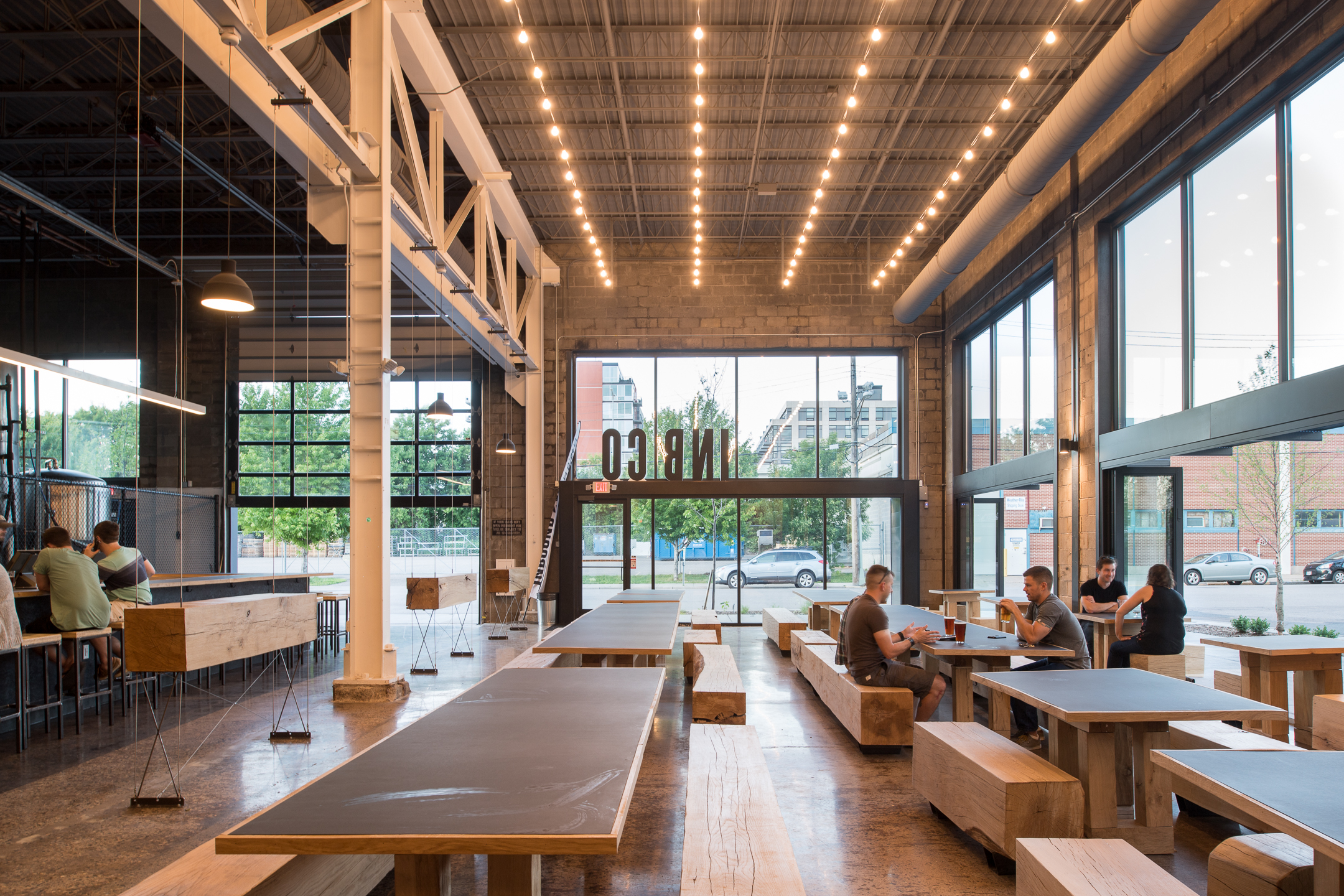 Custom wood tables and benches in modern brewery in Minneapolis by Christian Dean Architecture.