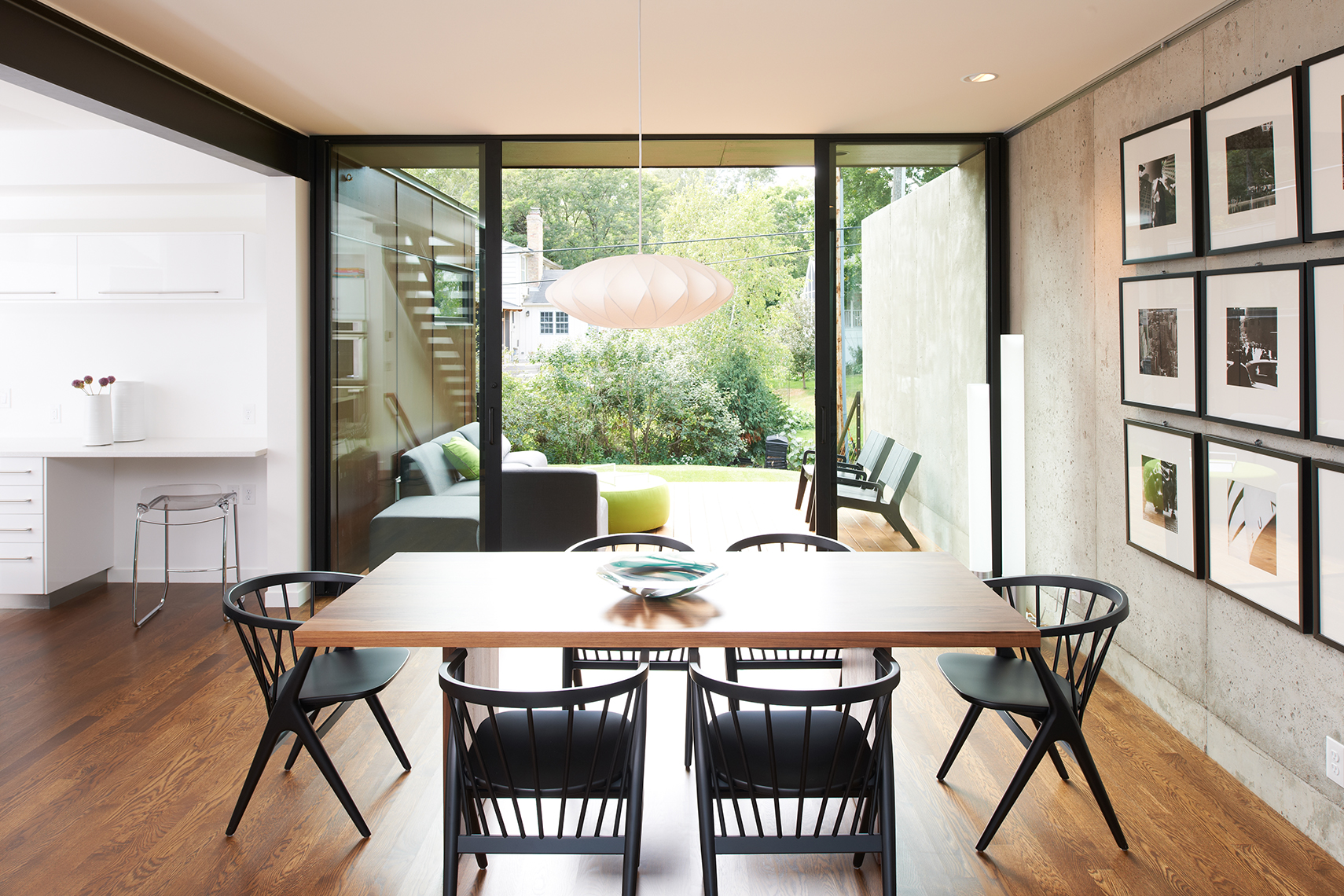 Modern dining room overlooking yard through full-height sliding glass door