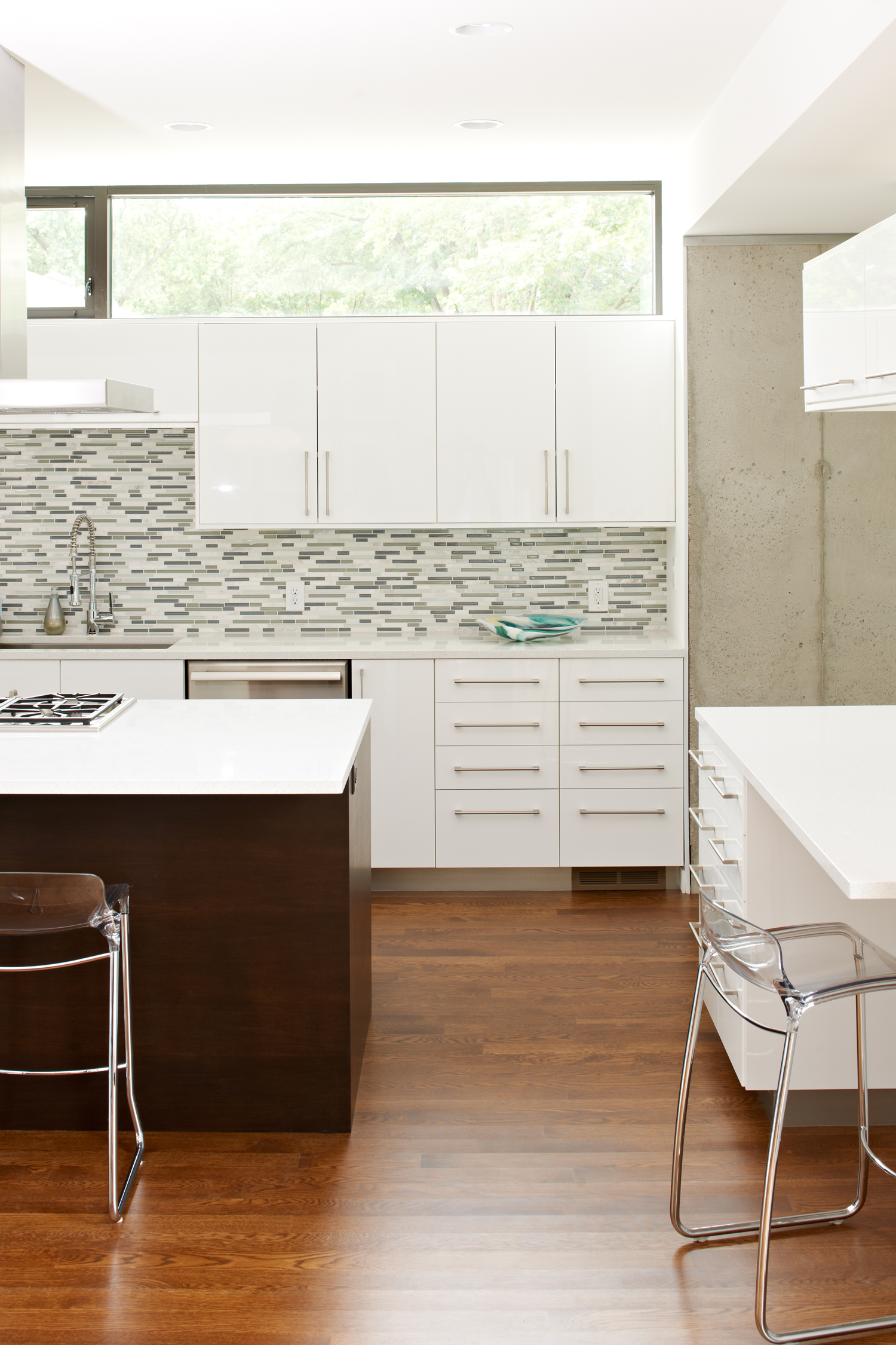 Modern kitchen with white cabinetry and grey tile backsplash