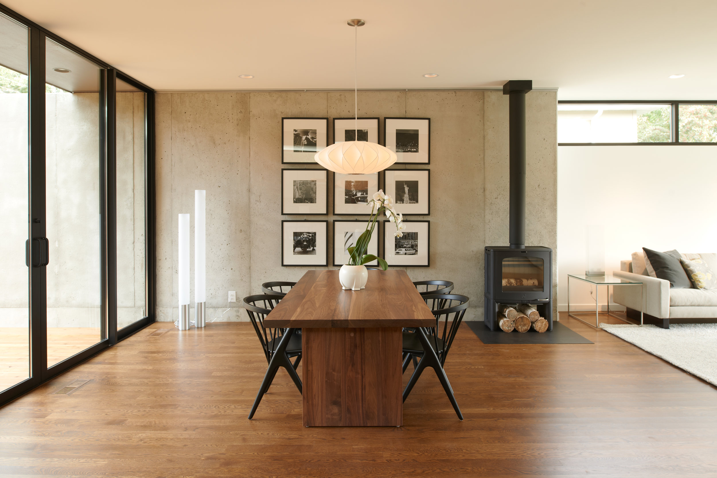 Modern dining room with wood floor and concrete wall