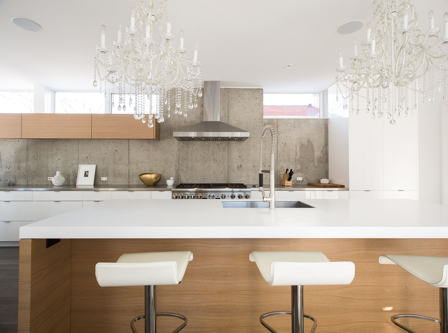 Modern kitchen with mixed white and wood cabinetry and exposed concrete walls