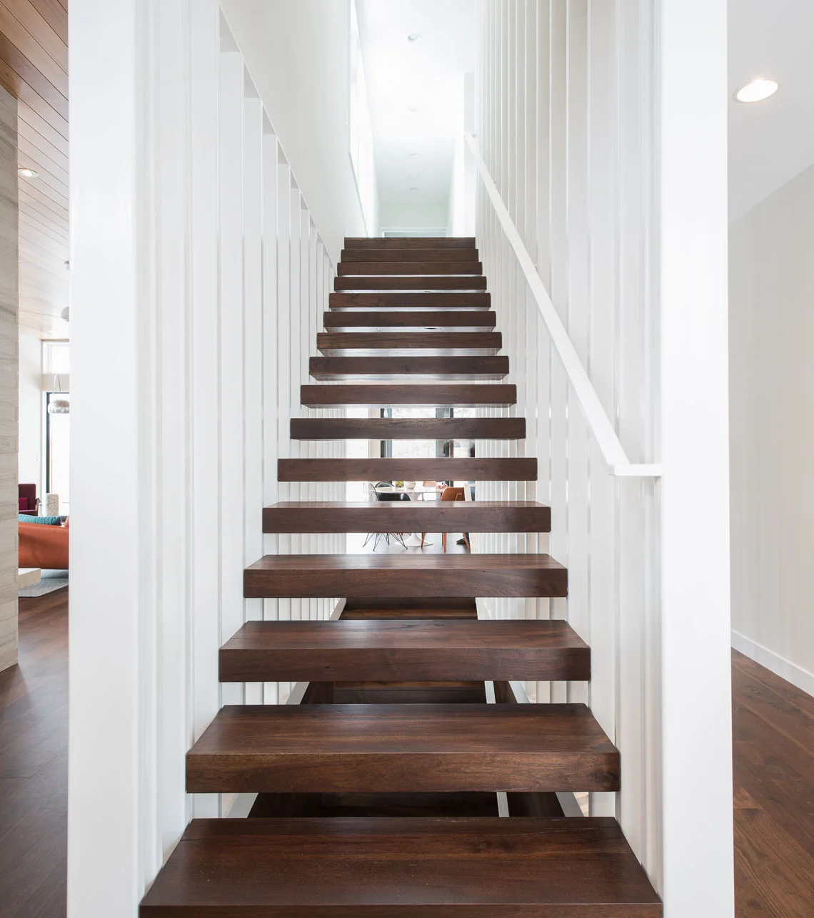 Custom sculptural floating tread stair with slat walls