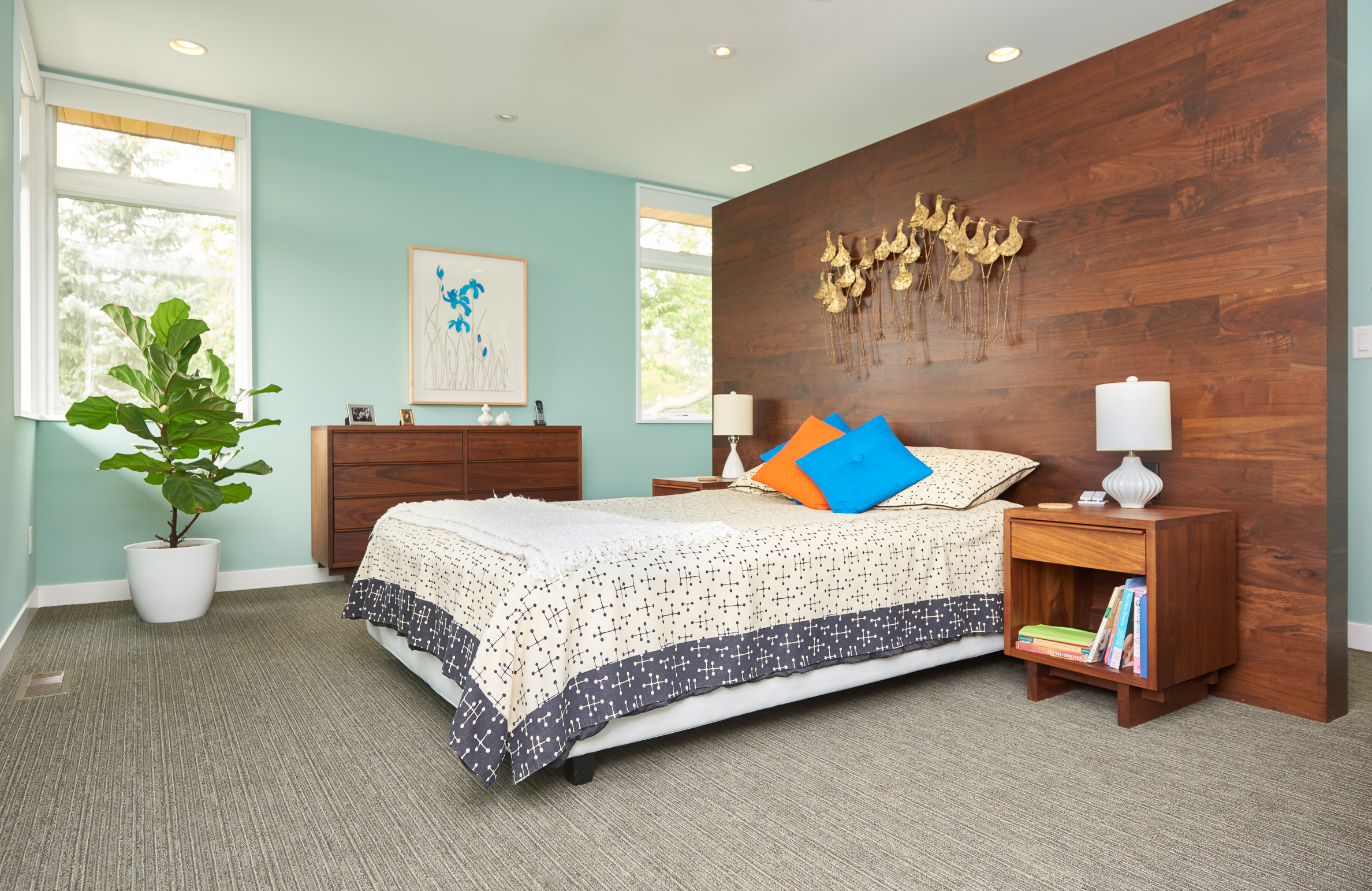 Midcentury master bedroom with custom headboard wall