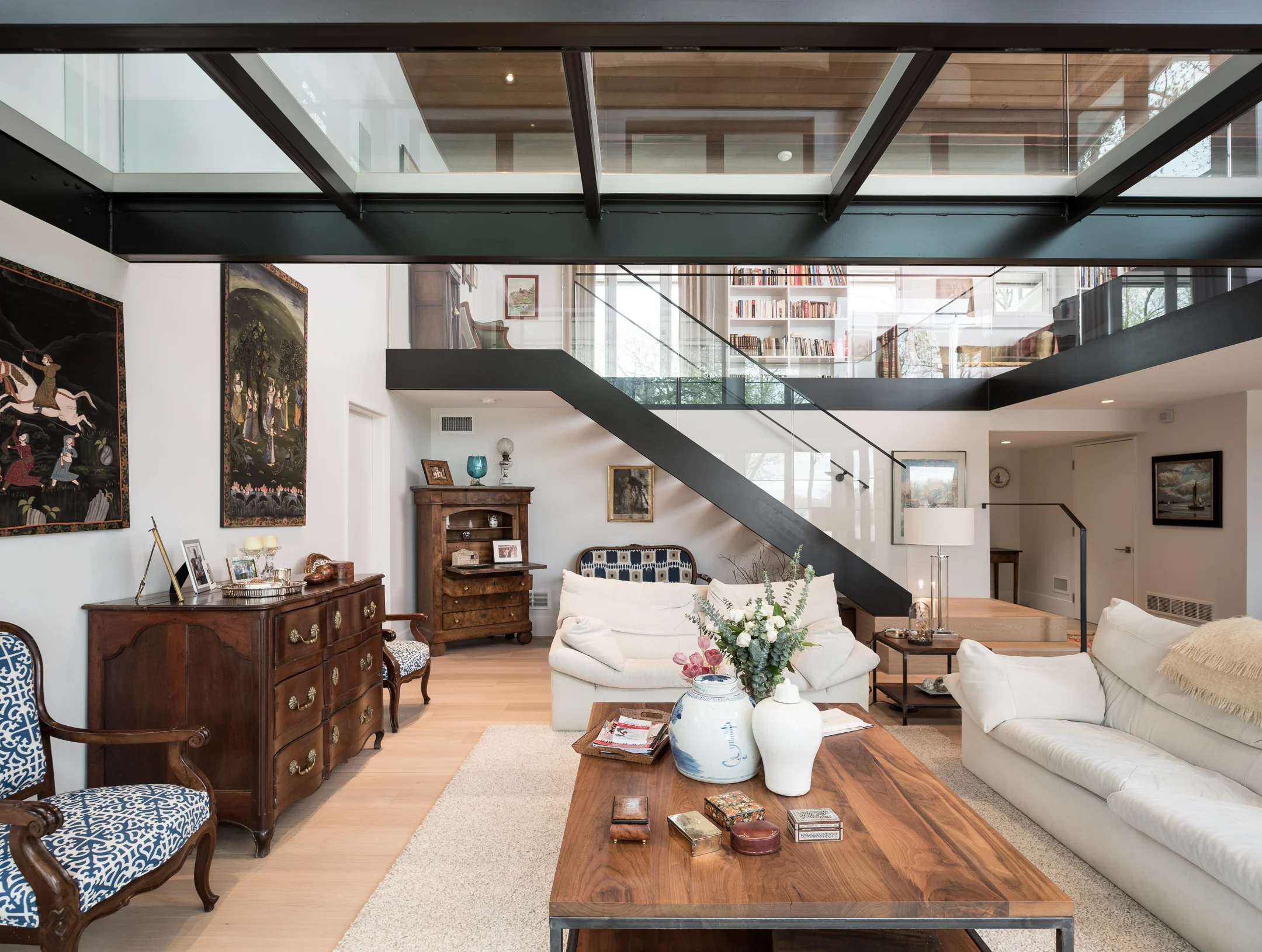 Custom interior glass bridge over vaulted living room