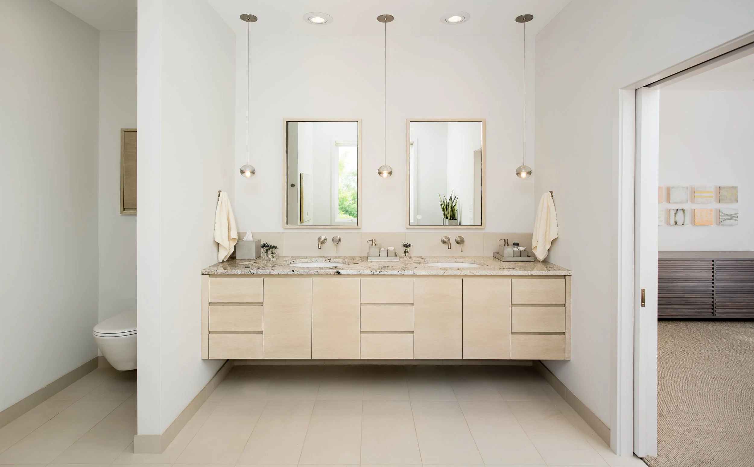 Custom floating master bathroom vanity with concealed toilet