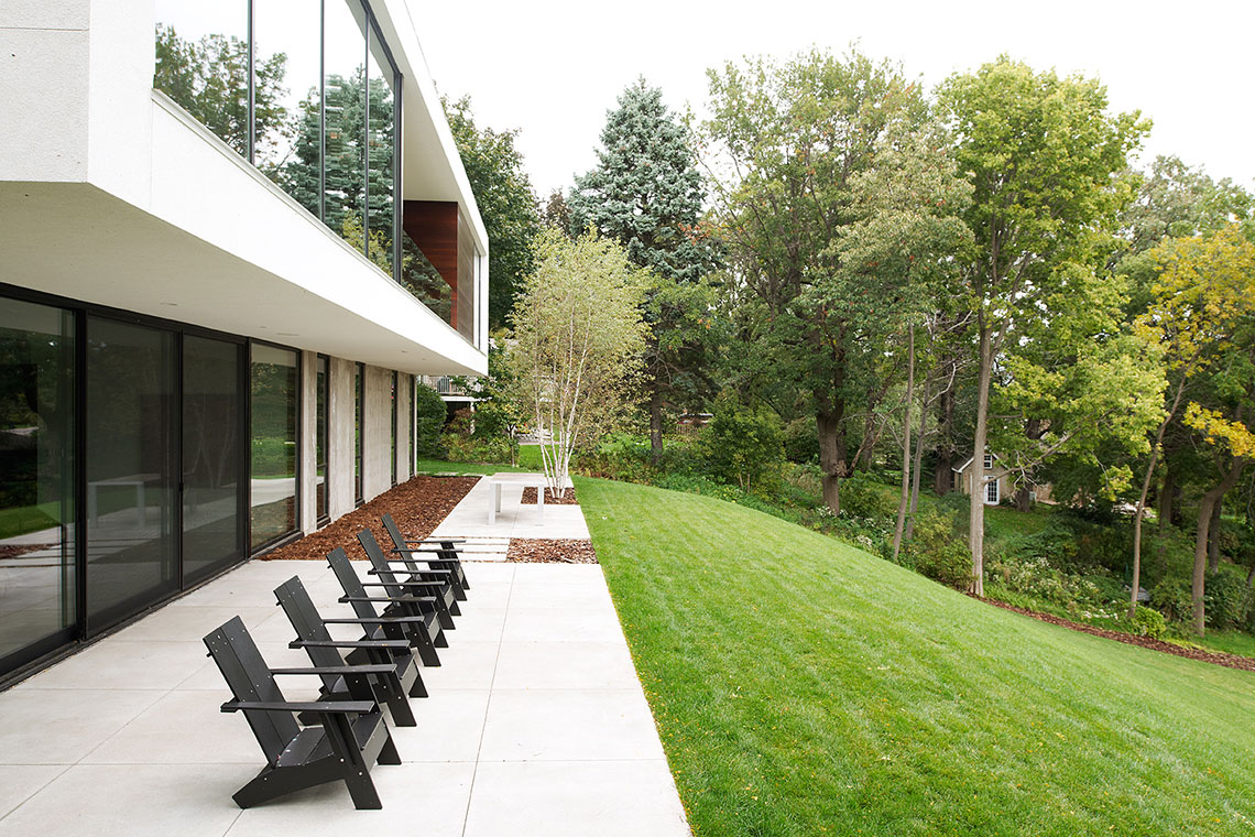 Patio beneath a modern lake home designed by Christian Dean Architecture