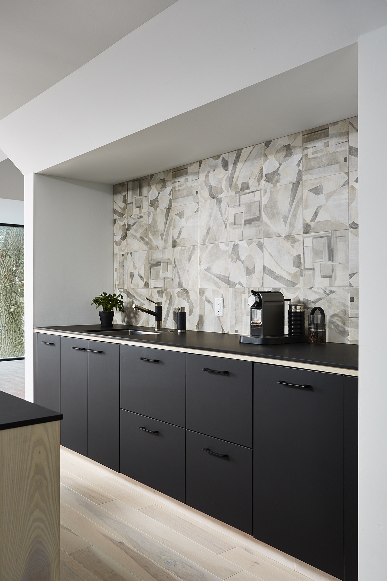 Recessed kitchen working area with graphic tile backsplash