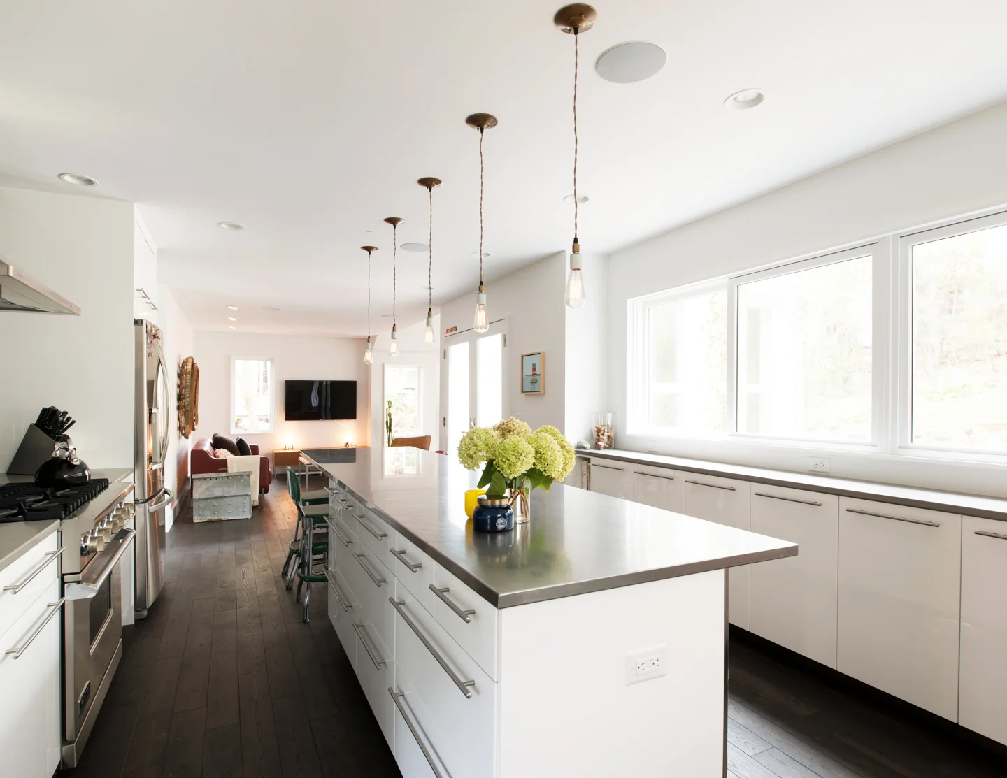 Modern white kitchen renovation with edison bulbs over large center island