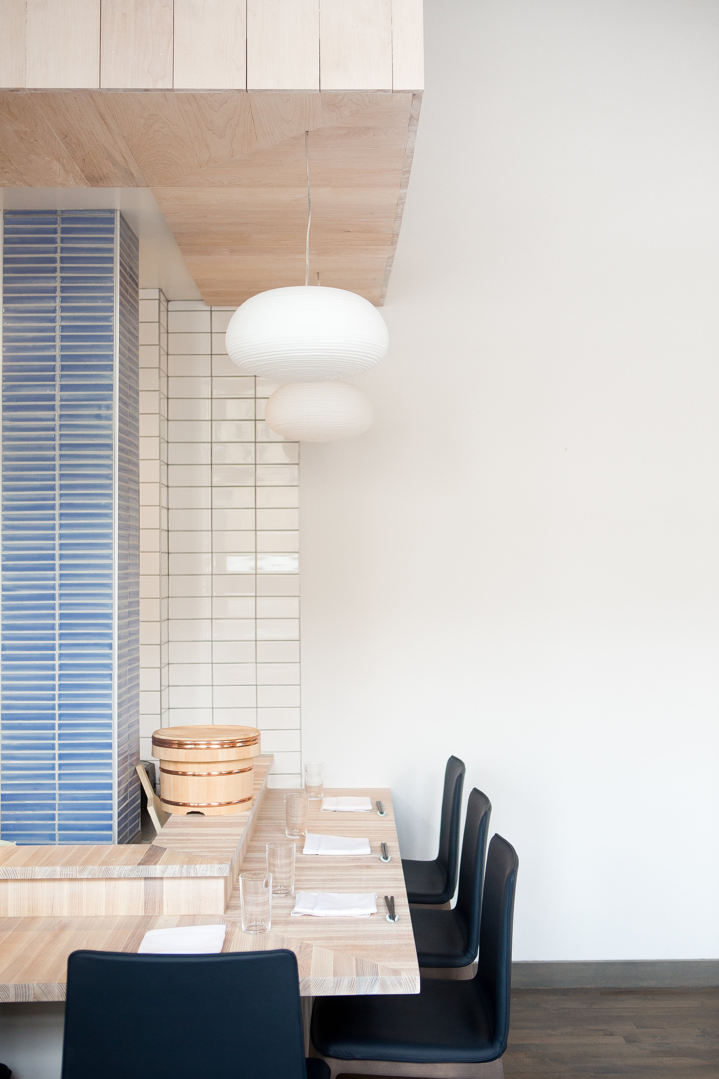 custom wood bar in restaurant with horizontally stacked gridded tile