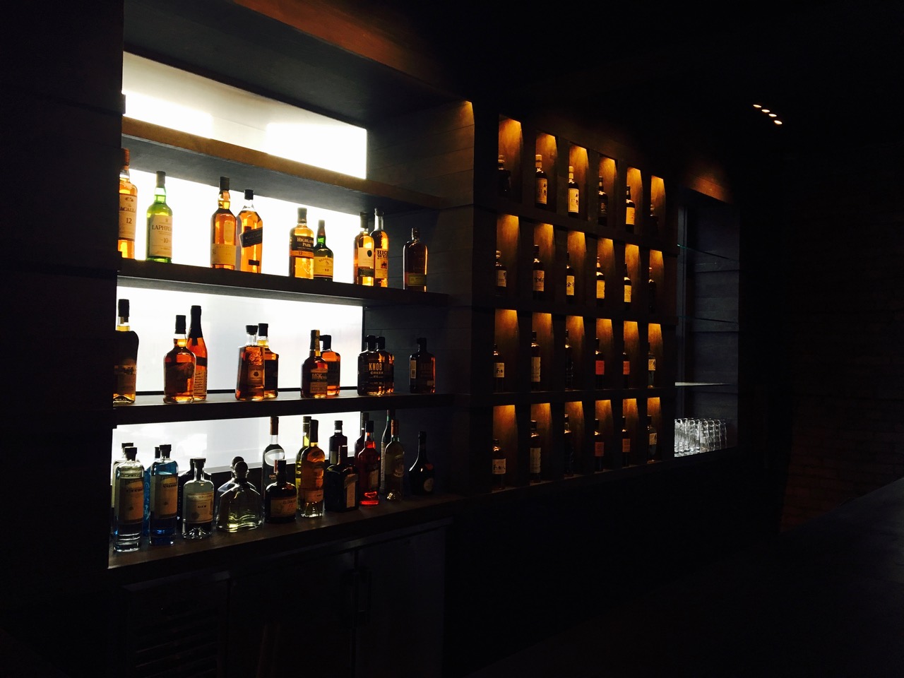 modern custom wood bar and back-lit bottle display