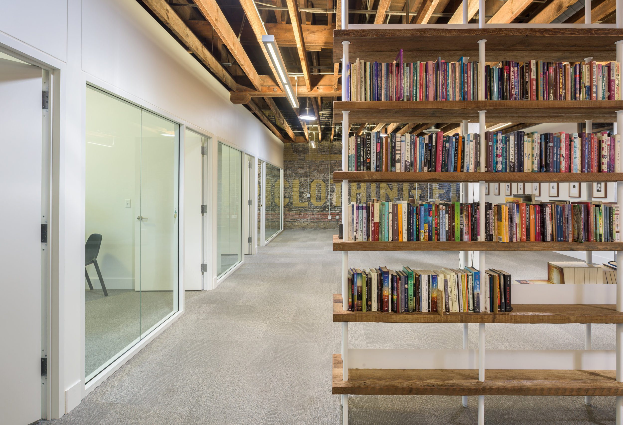 Custom metal and wood bookshelves in modern office space by Christian Dean Architecture.