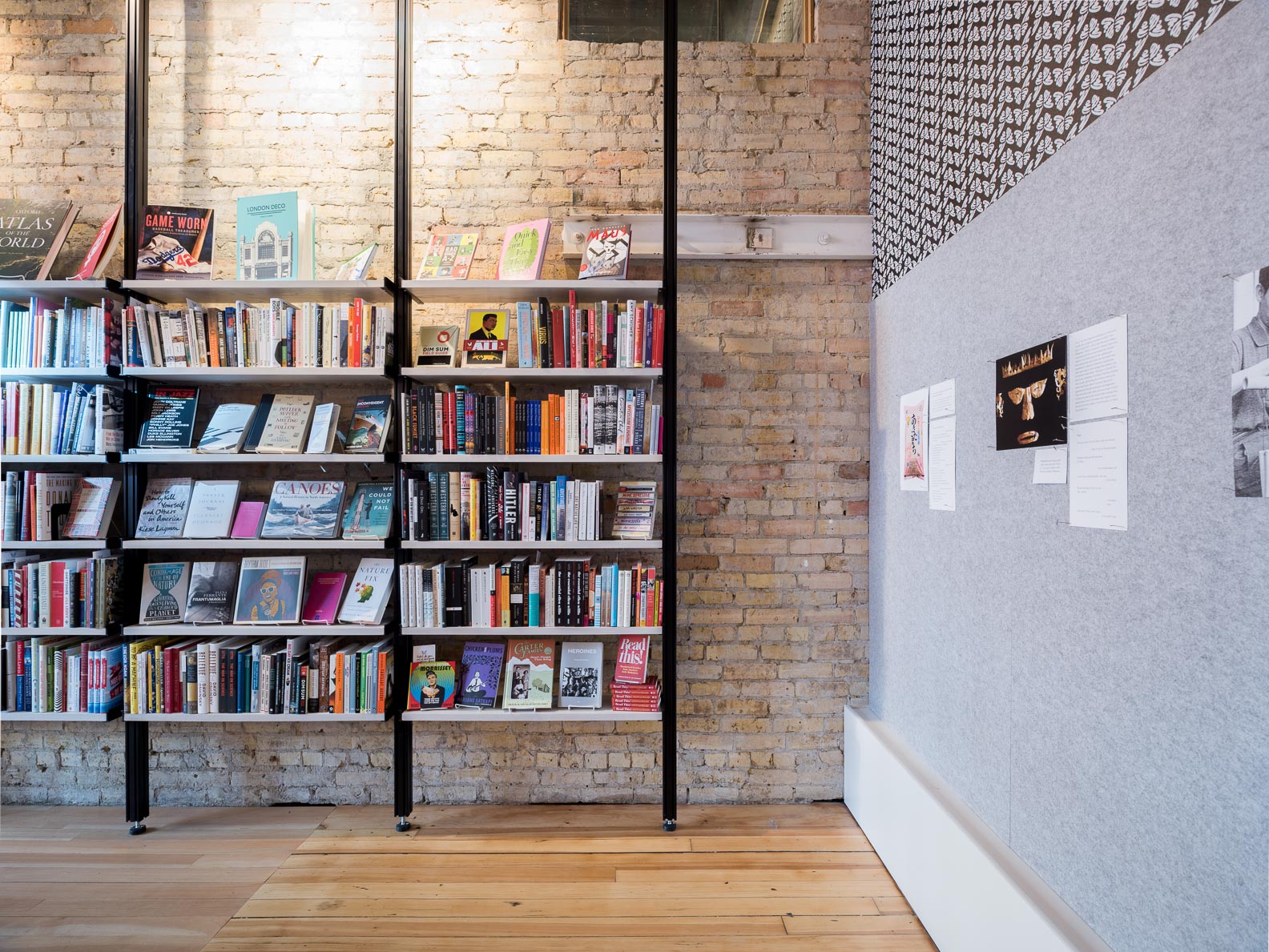 modern open steel and wood bookshelves against aged brick wall