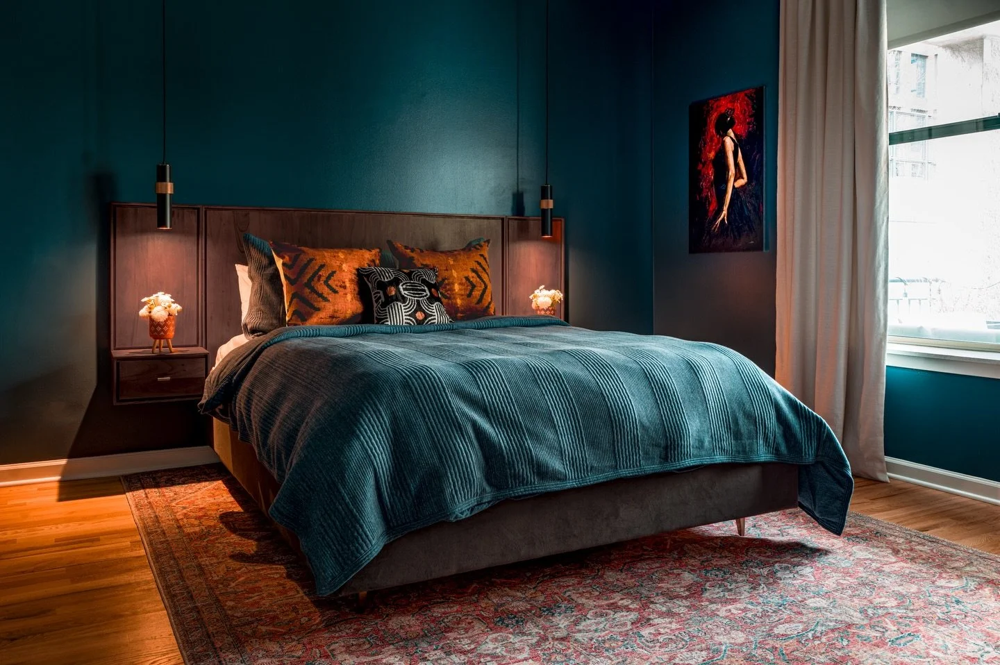 Moody teal walls set the stage, while layers of burnt amber and inky black bring the drama - proof that bold color isn&rsquo;t loud, it&rsquo;s intentional. Every tone here plays its part, from the rich, warm wood to the soft blue textiles, creating 