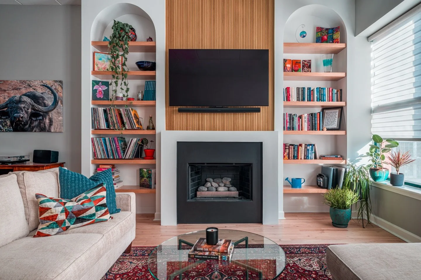 We transformed an underutilized space into a custom built-in moment - layering warm wood tones, clean lines, and fun arches to frame the fireplace and give the TV a true home. The added shelving brings both function and personality, turning everyday 