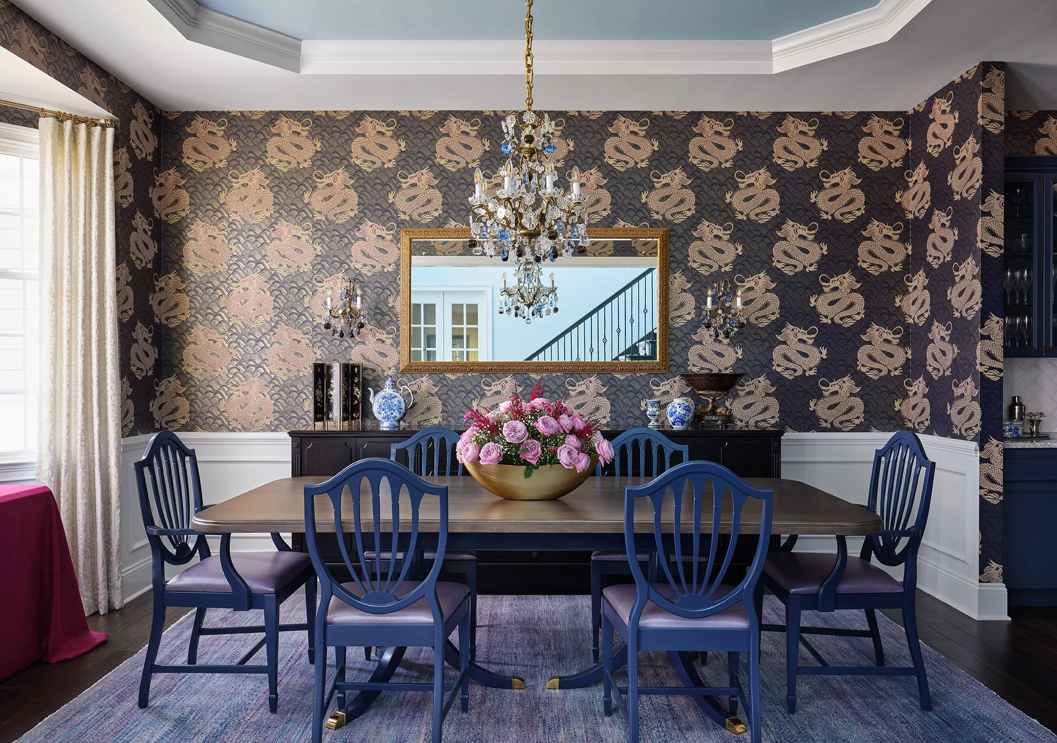 Luxury Chicago dining room designed by Sarah Jacquelyn Interiors featuring a walnut dining table, forest green velvet chairs, custom window treatments, statement lighting, and layered interior design.