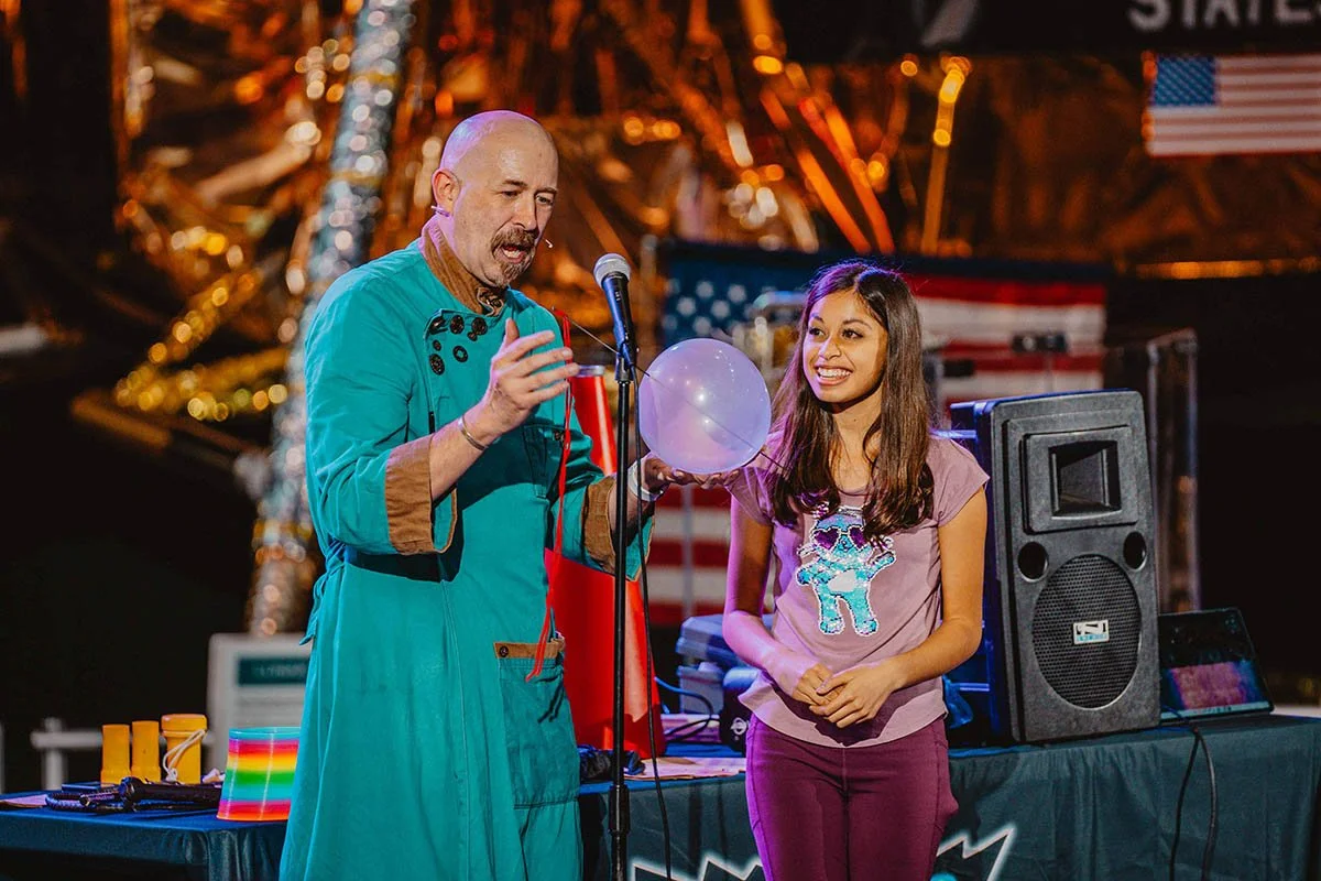 Hagerman and a student volunteer during a Sound of Science assembly demonstration