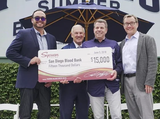 Cody Martinez, Chairman, Sycuan Band of the Kumeyaay Nation, Former County Supervisor Ron Roberts and Tom Seidler SVP, Community & Military Affairs, San Diego Padres present SDBB CEO David Wellis with a check for $15,000 at the 2nd Annual Padres Blood Drive in 2018 at Petco Park
