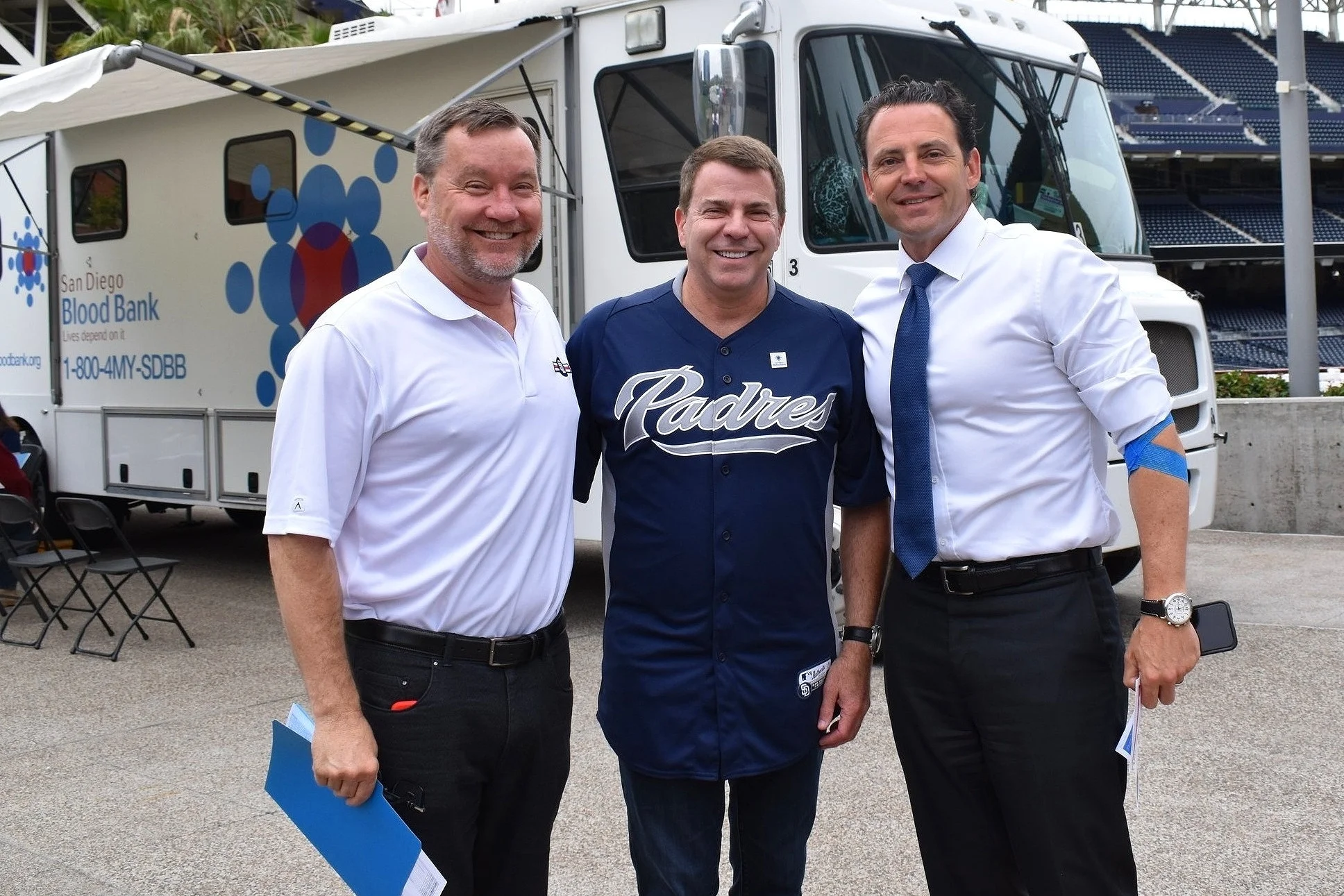 San Diego Padres’ SVP, Community & Military Affairs Tom Seidler prepares to donate blood as he stands with SDBB CEO David Wellis and County Supervisor Nathan Fletcher, who just completed his blood donation at the drive.