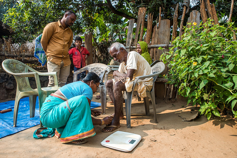 A community health worker trained by Intelehealth in rural Odisha evaluating a patient.