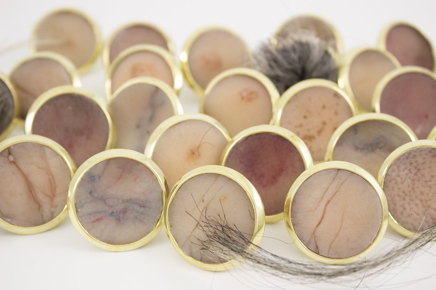 Marilyn Koch , Detail of Year 30: Age Badges , 2016 Brass, nickel, silicone, pigment, synthetic hair, fibers 1 x 1 x 1 inches Photo courtesy of artist
