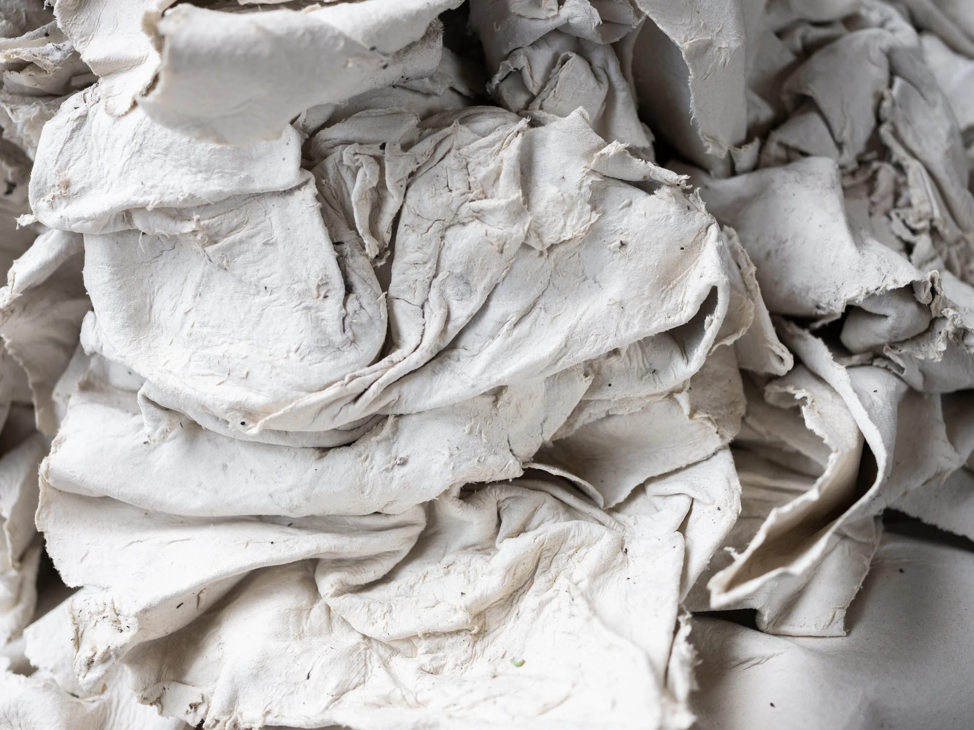 Scrunched up white supernatural paper during the manufacturing process, looks like normal paper pulp.