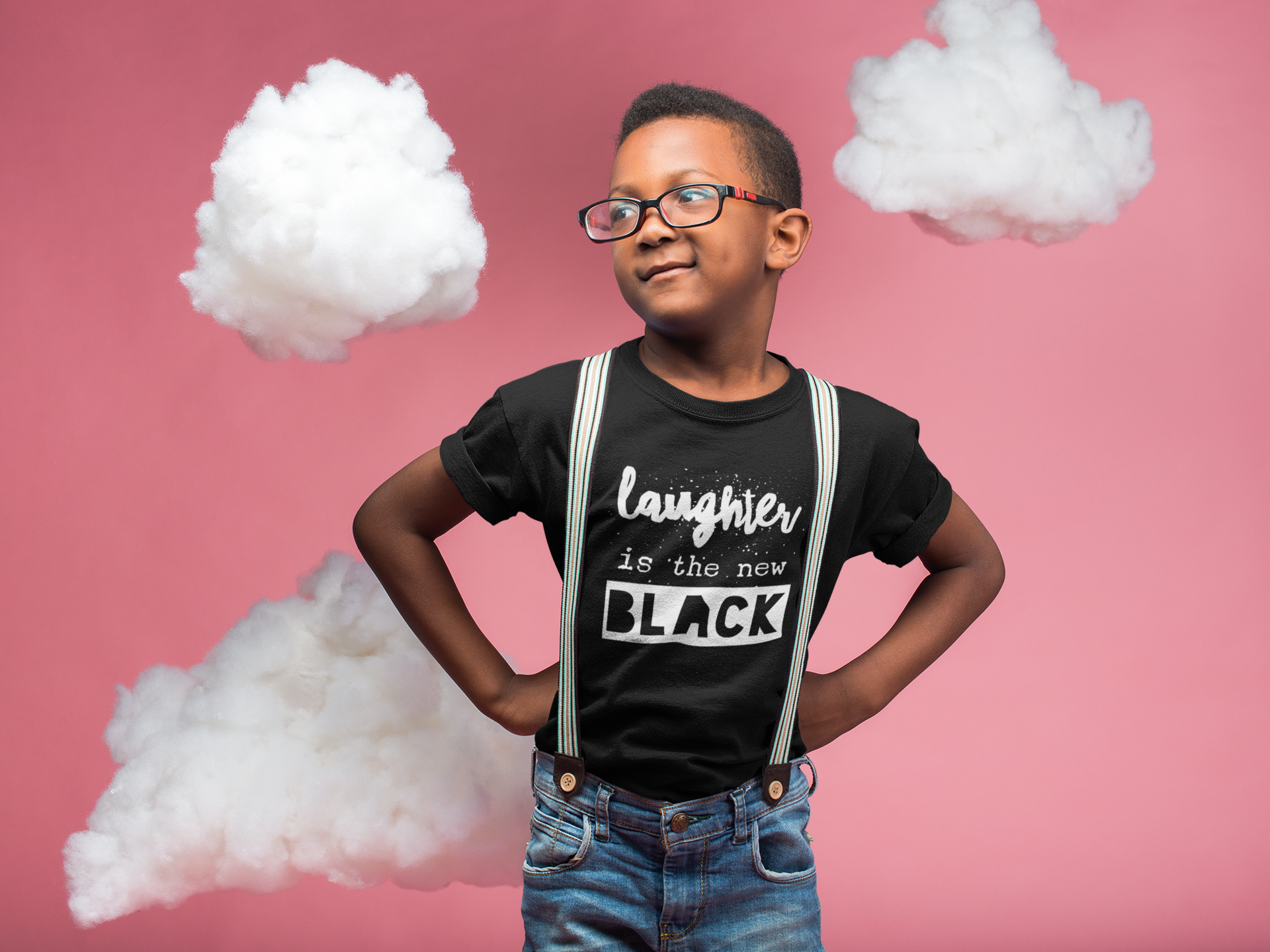 black-kid-wearing-a-t-shirt-mockup-and-glasses-while-standing-in-a-pink-room-with-clouds-a19727.png