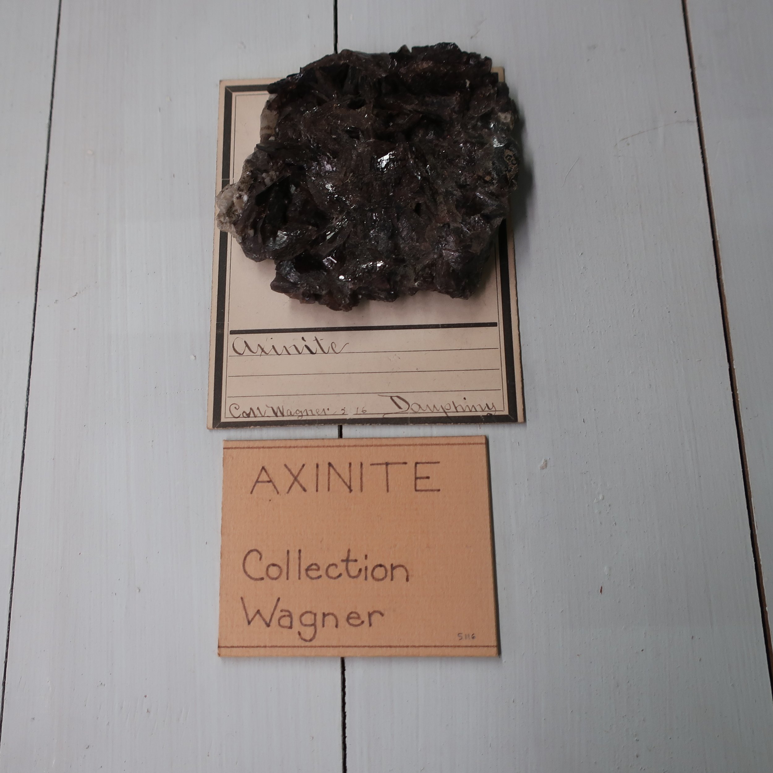  “ Axinite  contains Silica 50, Alumina 16, Lime 17, Iron 9 Manganeese 5. Sp. Gr. 3.27. This mineral rarely occurs massive, more frequently in flat, oblique rhomboidal prisms, whose edges are remarkable sharp. Common colour violet, or clove brown, al