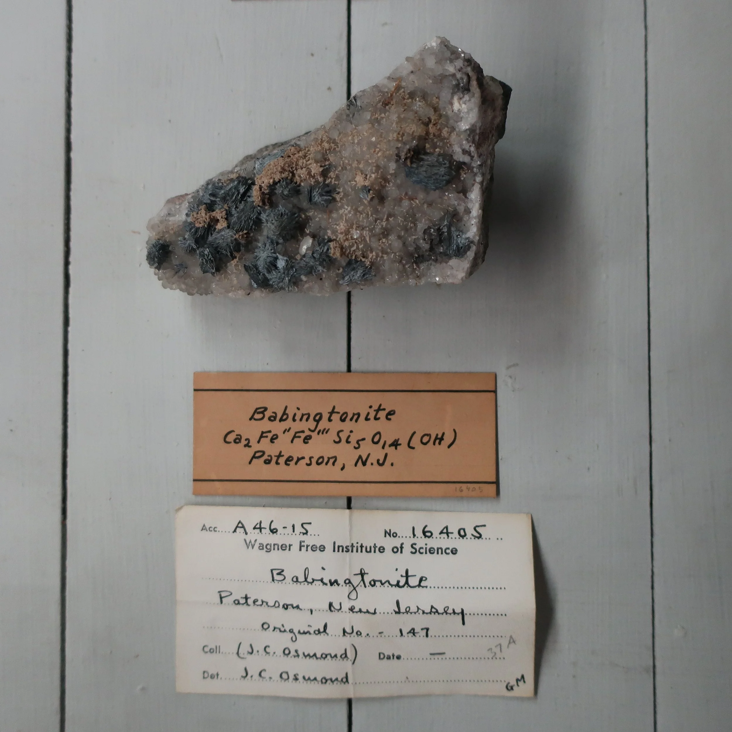 “Babingtonite is another variety of Augite, the lustre is vitrious, surface brilliant, B.B. it fuses into a black enamel. It resembles some of the dark varieties of augite from which it was first distinguished by Levy. It is composed of Silica Iron manganeese and lime with a trace of titanium. But it would seem, that no one has had sufficient of this mineral for a thorough analysis, it occurs in very distinct crystals at Arendal in Norway, with epedote and Garnet. The only locality in the U.S. is at Charleston, Mass.”