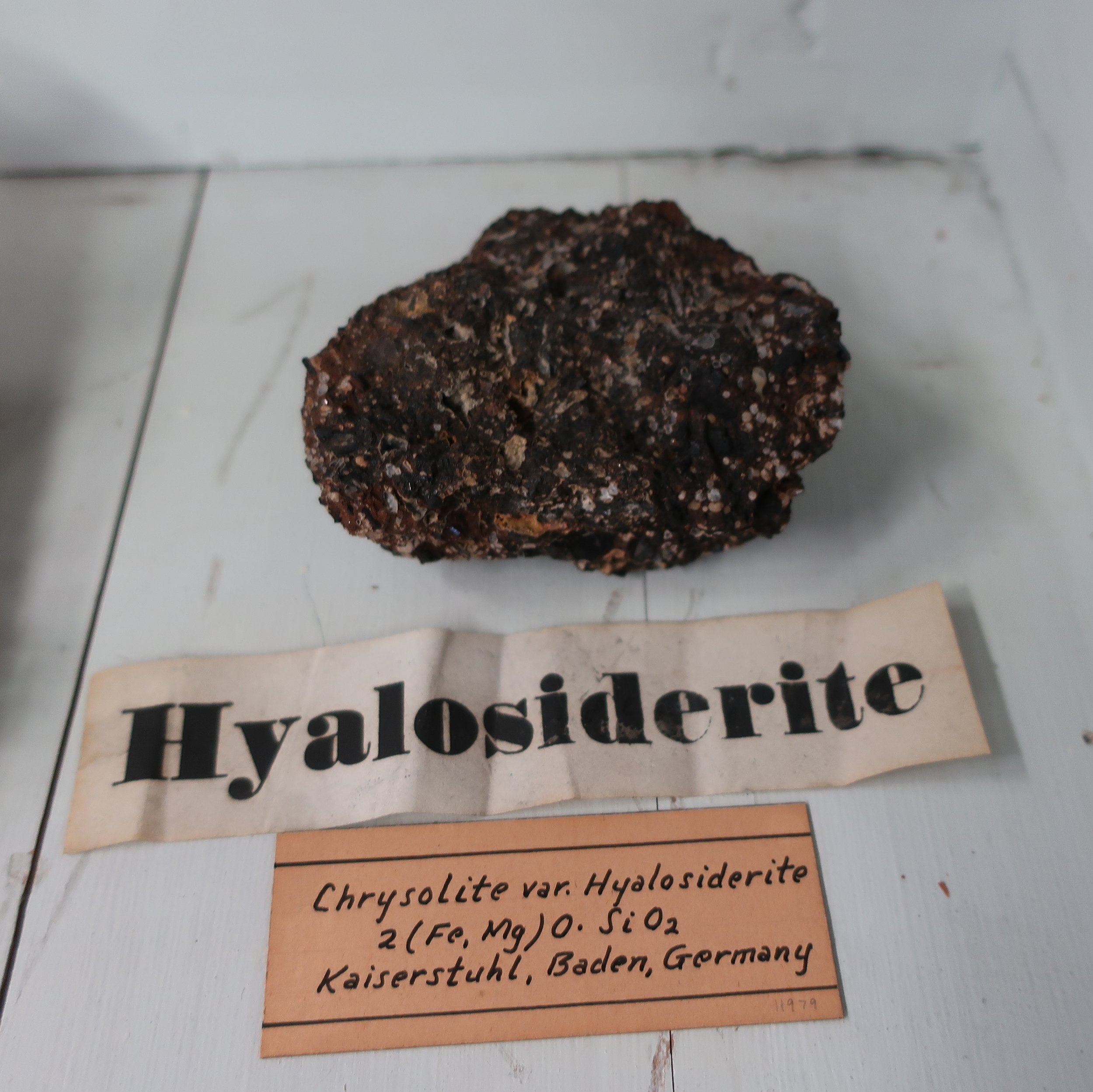   “Hyalosiderite  derives of 2 Greek words signifying Glass &amp; Iron. this mineral was found in amygdaloid rock. It is composed of Silica 32, Iron 30, Magnesia 32, Potash 3. Some mineralogists have considered this species a variety of Chrysolite. C