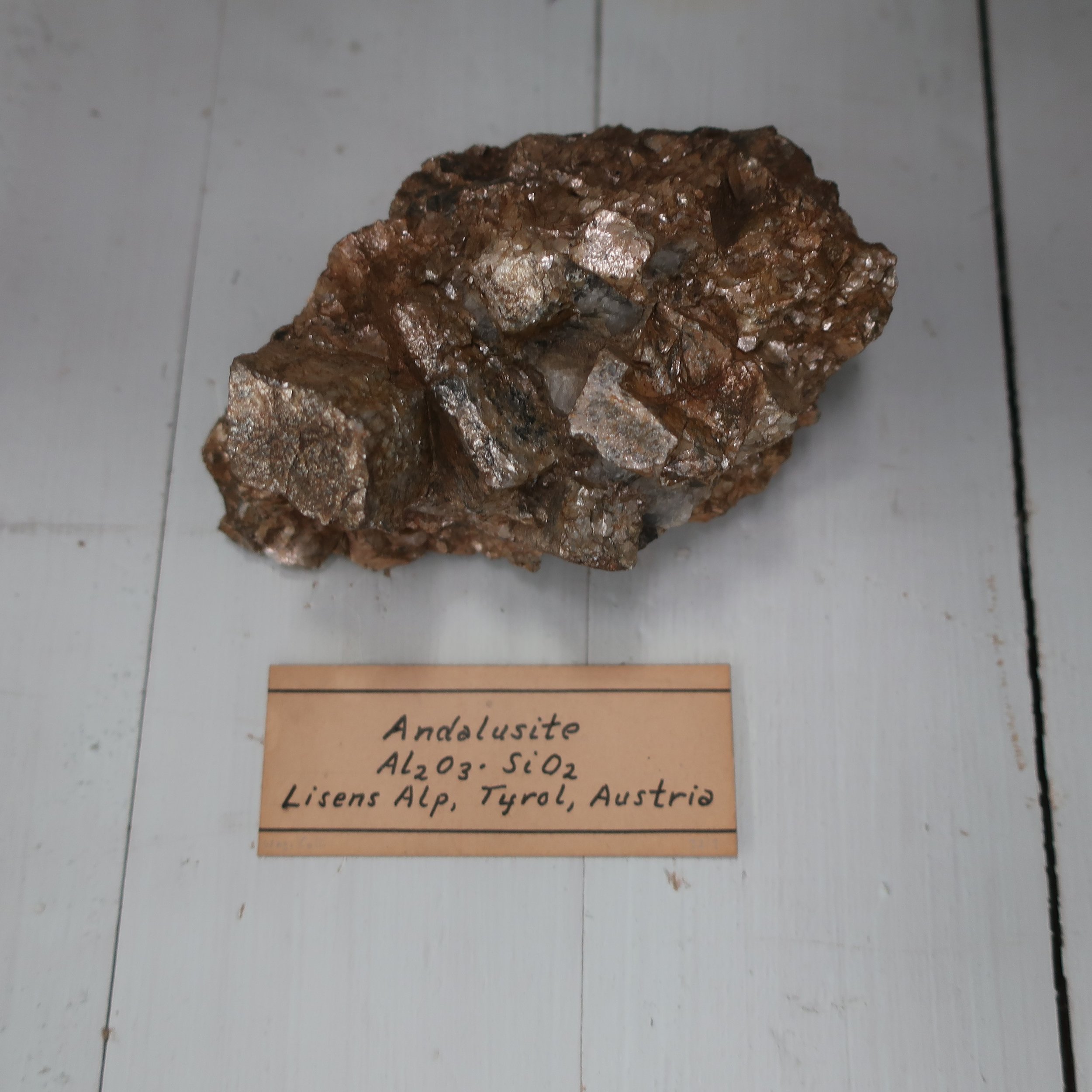   Andalusite  is essentially composed of Silica and Alumina, but contains several other accidental ingredients. Sp. Gr. 3.16. This mineral occurs massive, and in the primary form, a right rhombic prism. It has a lamellar structure with joints paralel