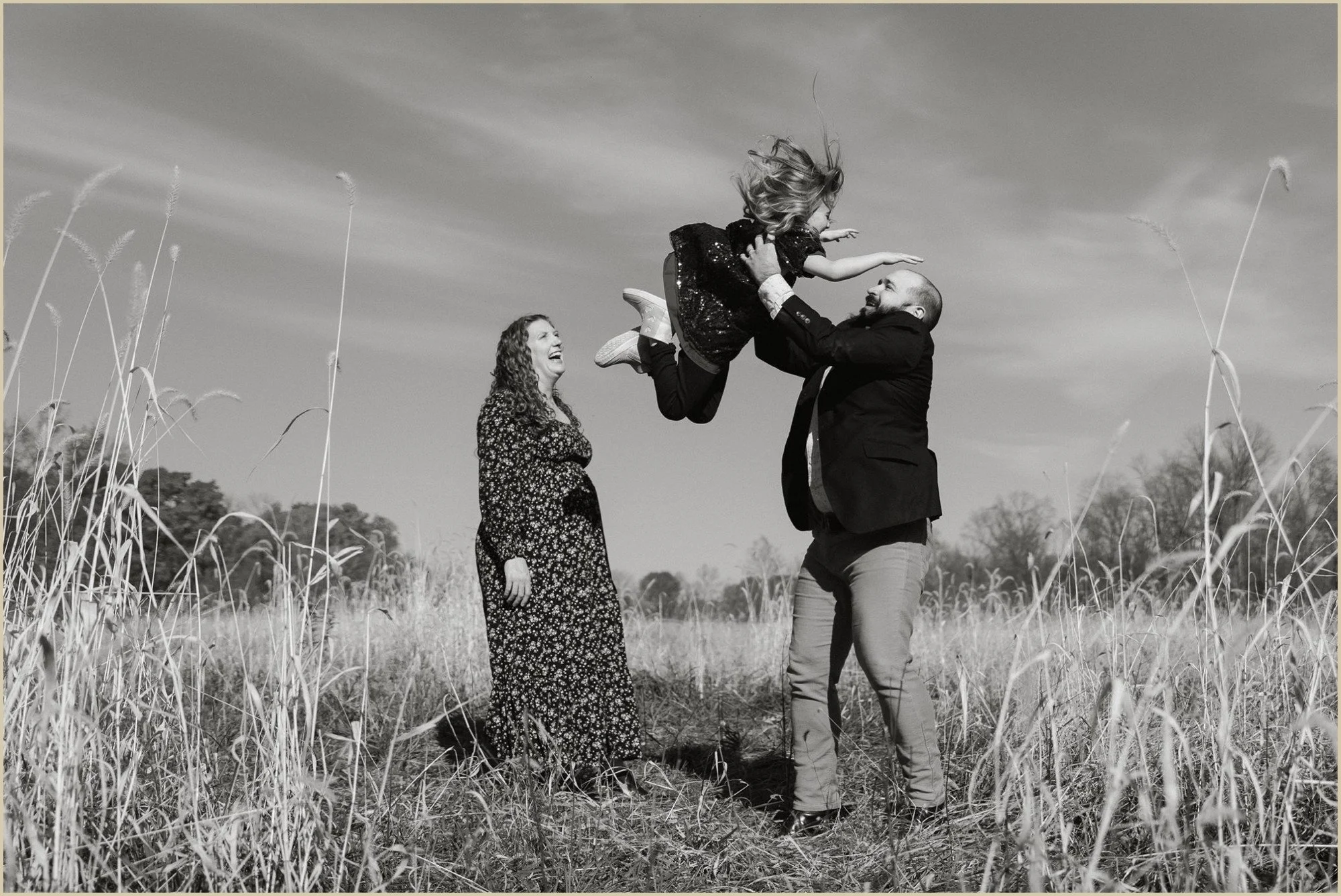 a family playing in a field documentary style family photo in Newtown, PA