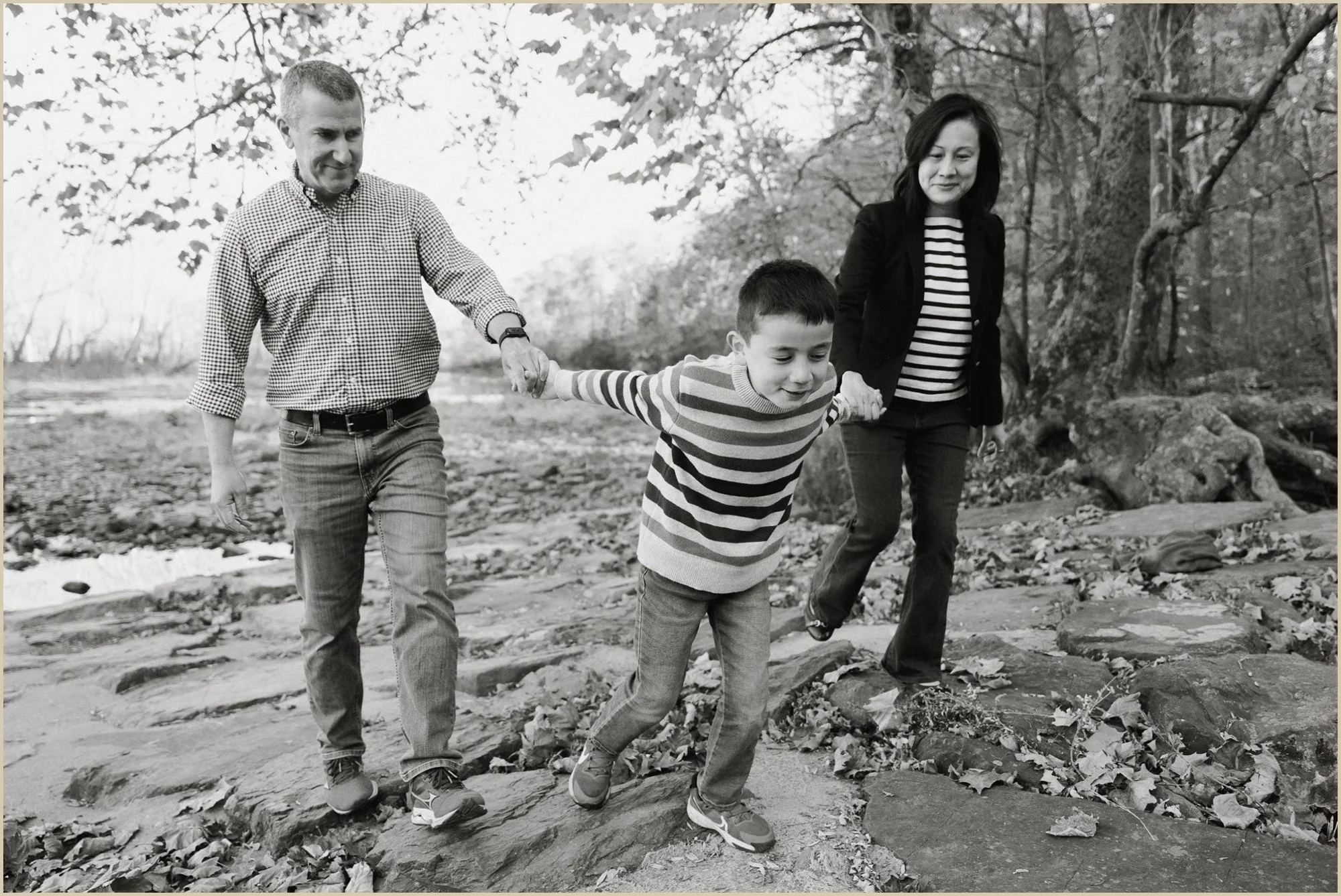 a family holding hands candid family photo at Tyler State Park in Bucks County