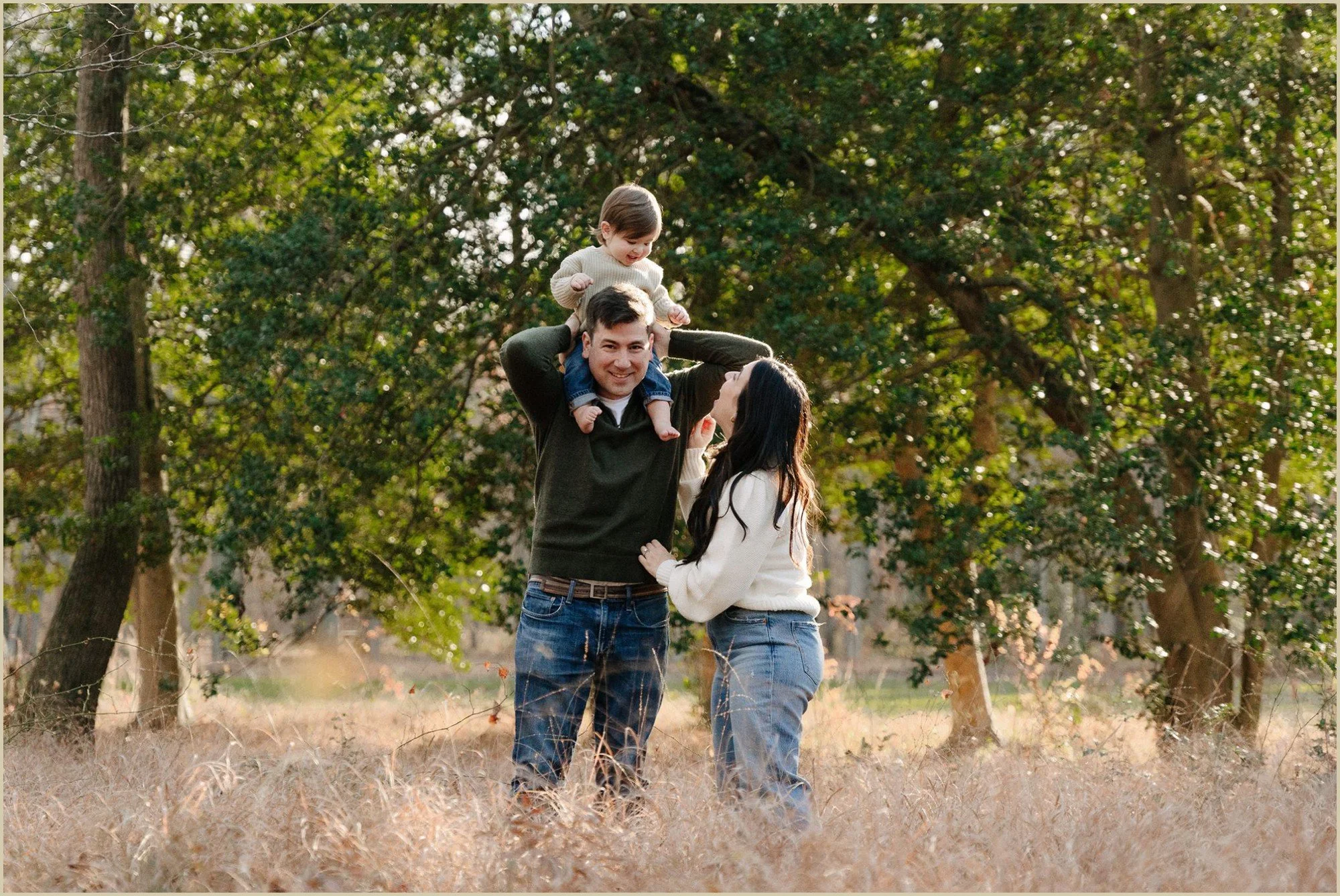 a family in a field laughing candid family photography