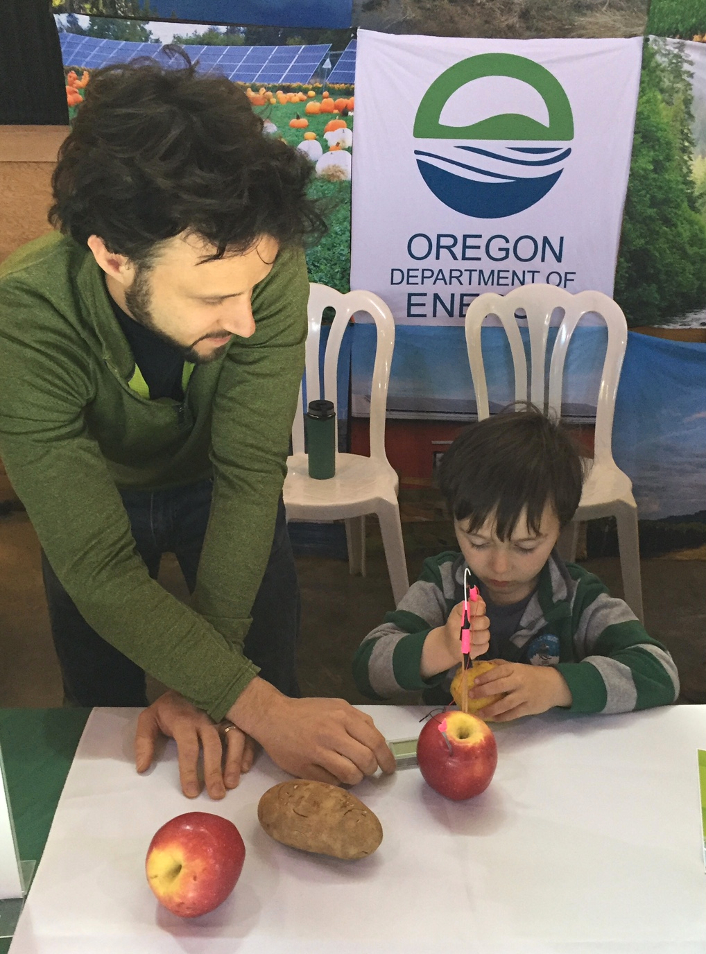  During an Earth Day event at the Oregon Garden in  Silverton , ODOE Engineer Blake Shelide showed a young boy how to create an electric current using fruits and vegetables.     