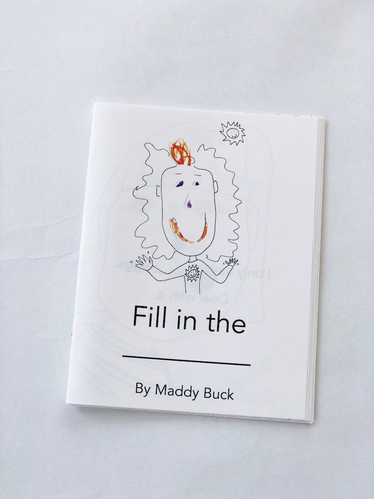  Cover of a picture book called Fill in the _______ by Maddy Buck. We see a girl with a silly, glad face. Her eyes, nose, and mouth are created with collage bits of watercolor paper that have been painted. 