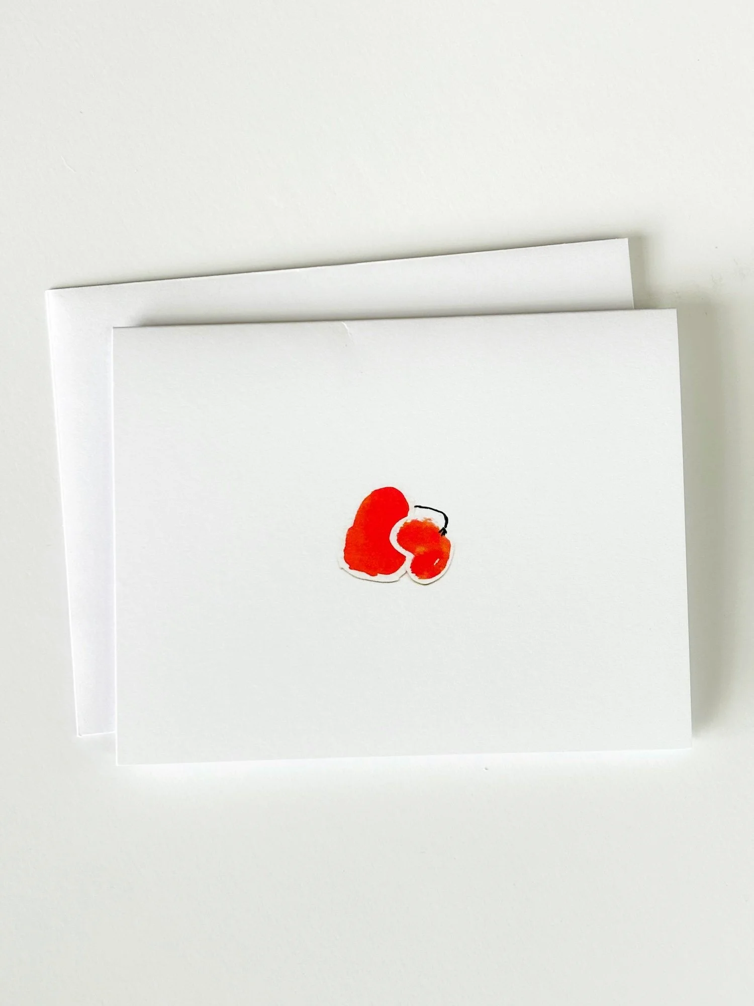  This is a photo of a greeting card, where the cover shows two blobby red collaged circles, one bigger than the other. The blobs represent a parent and child and we see a little arm going from the big blob to the little blog, as if giving a hug. 