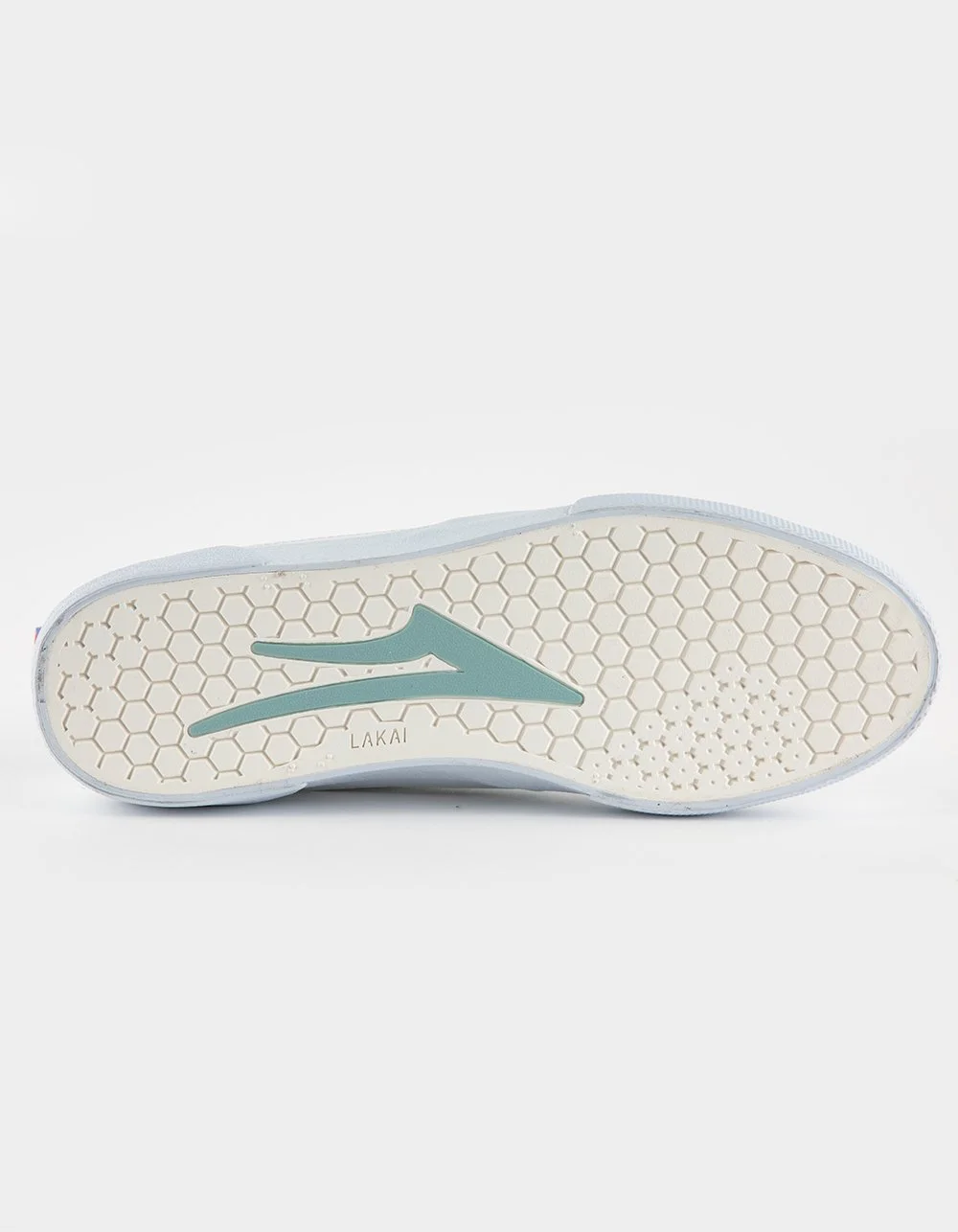 The sole of a light-colored athletic shoe with a honeycomb pattern and a teal logo