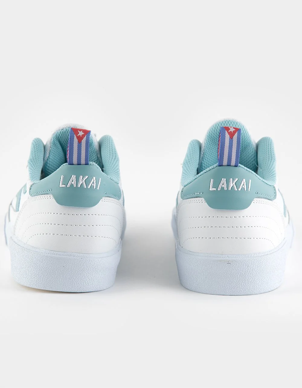 Pair of light blue and white sneakers with "LAKAI" branding on the back, viewed from the rear against a plain white background.