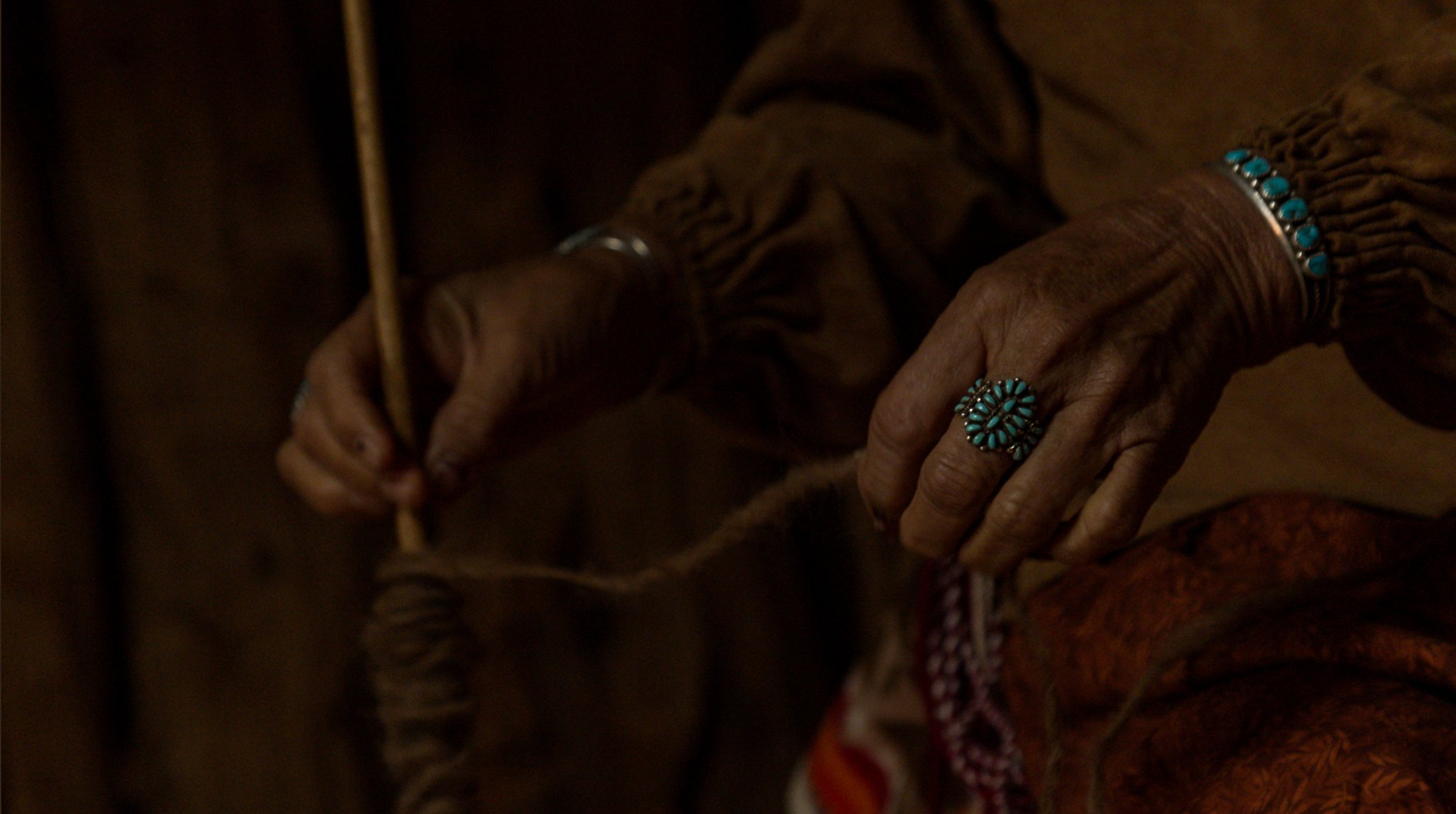  A closer look at Effie Yazzie’s hands as she uses the spindle to stretch her yarn 