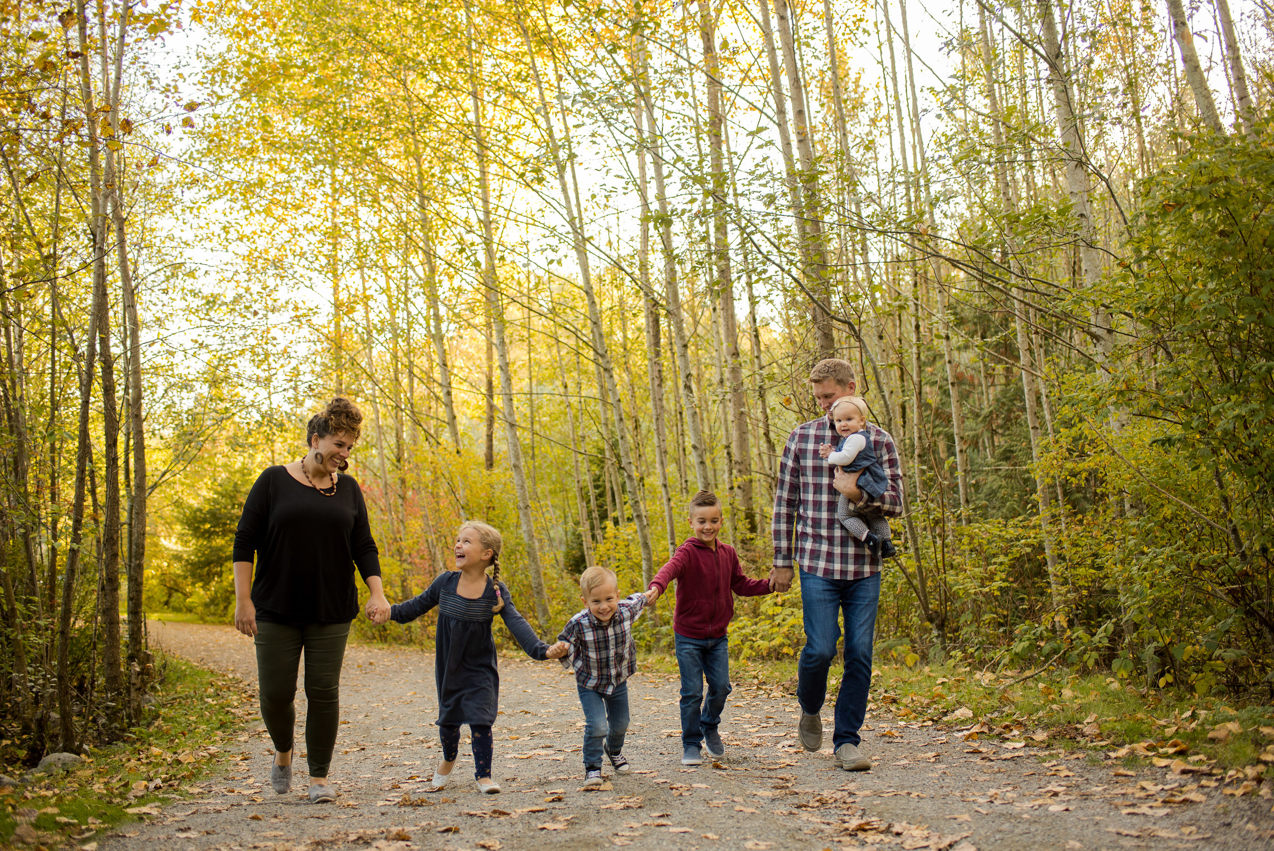 Family walking through forest during family session in Surrey BC