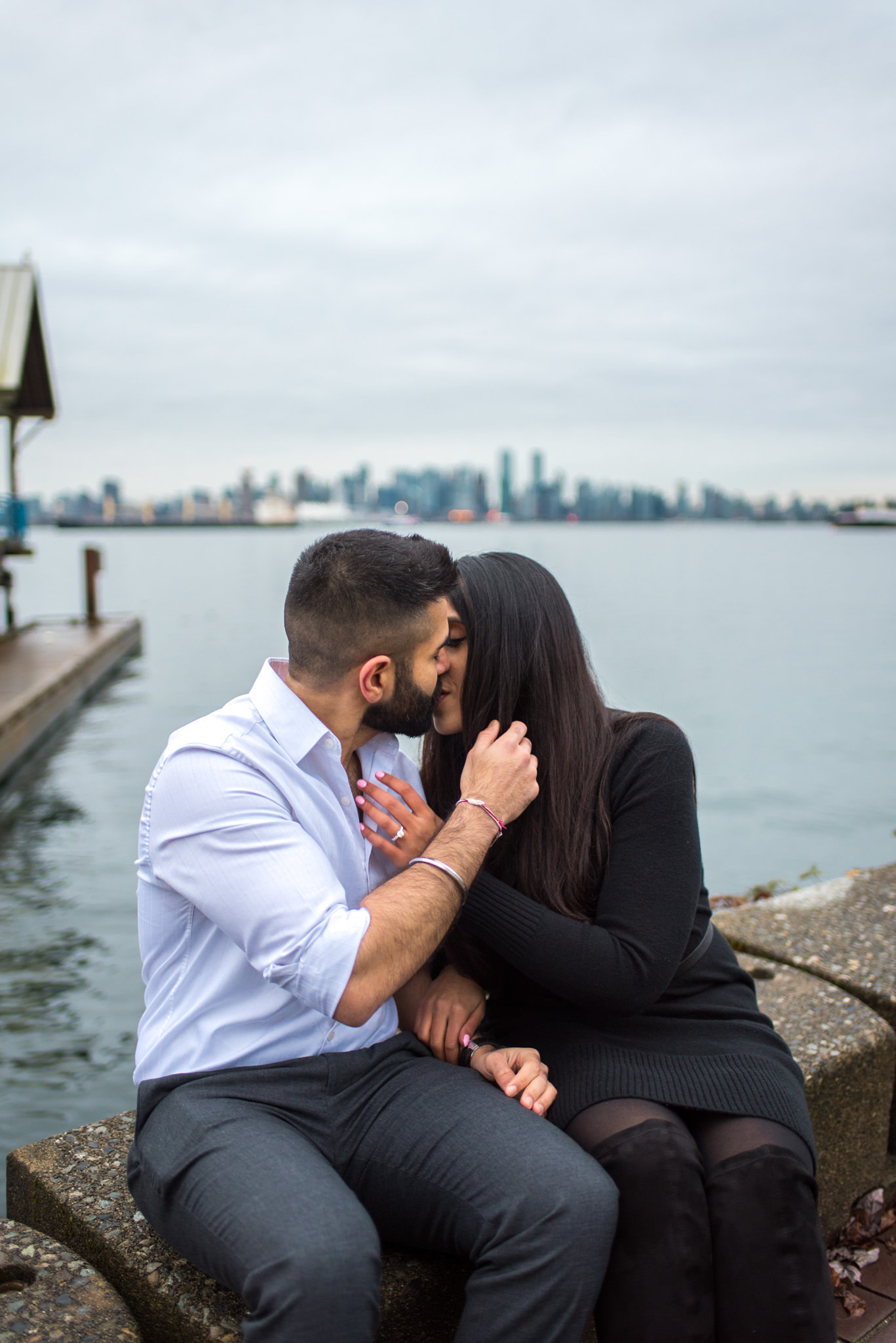 An engaged couple shares a kiss in North Vancouver BC