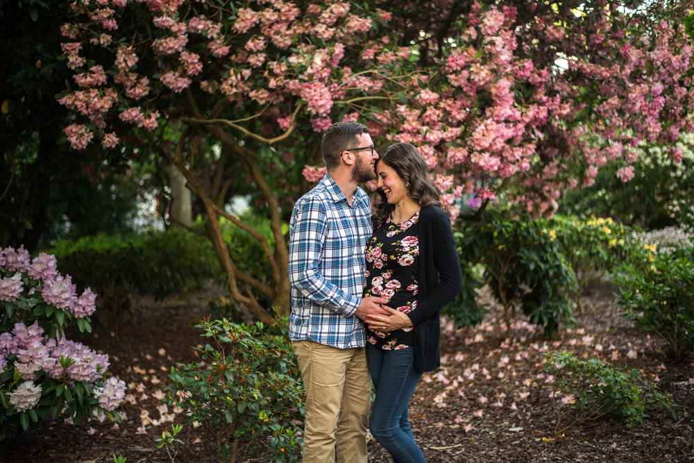 Expecting couple laughing in a park in Burnaby BC