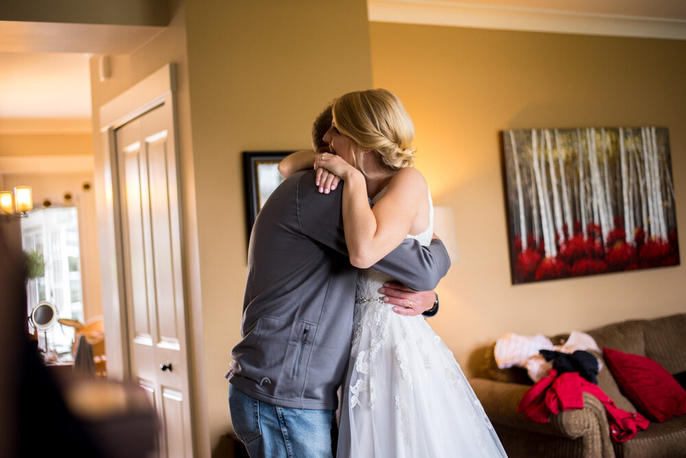 Bride and father of the bride share an embrace during their father-daughter first look