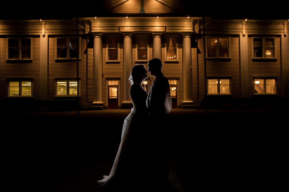 Bride and Groom pose for a silhouette photo in front of Fort Langley Community Hall in Fort Langley, B.C.