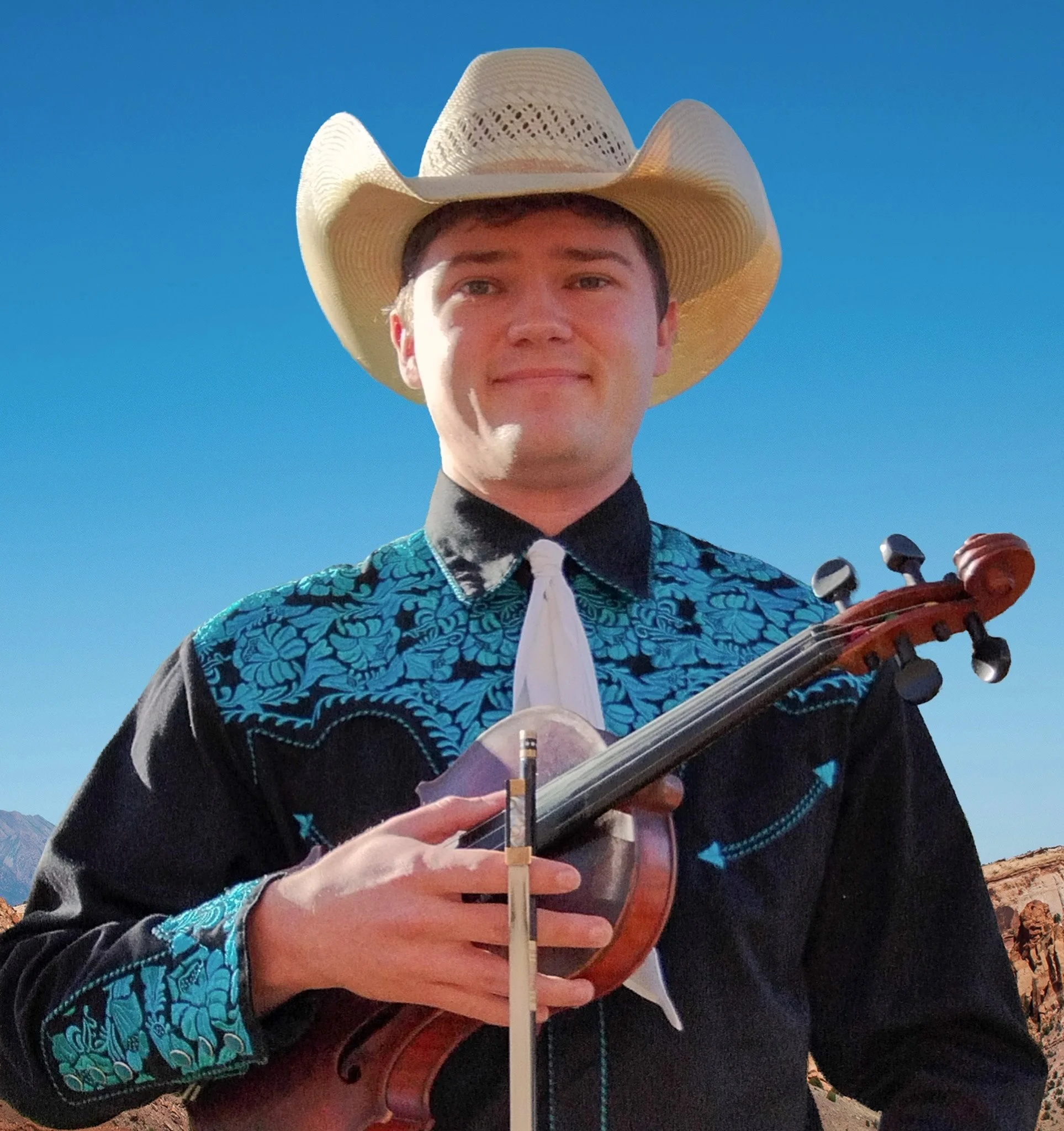 Two-time Nashville Grand Masters Fiddle Championship winner Trustin Baker holding his fiddle and smiling.