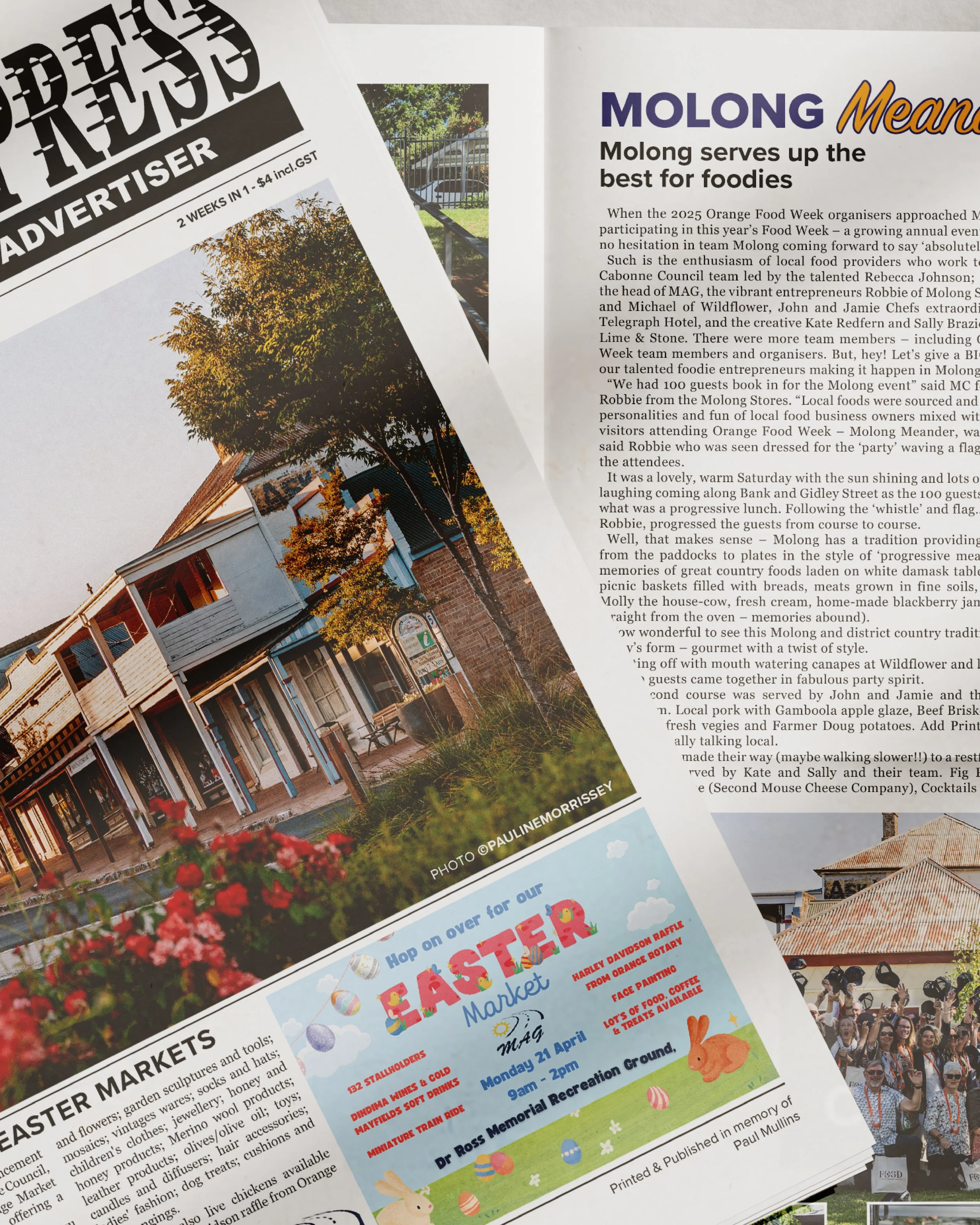 A newspaper page featuring a photograph of a street with a Victorian-style building, trees, and flowers, along with an advertisement for an Easter Market event happening on April 21 at Dr. Ross Memorial Recreation Ground.