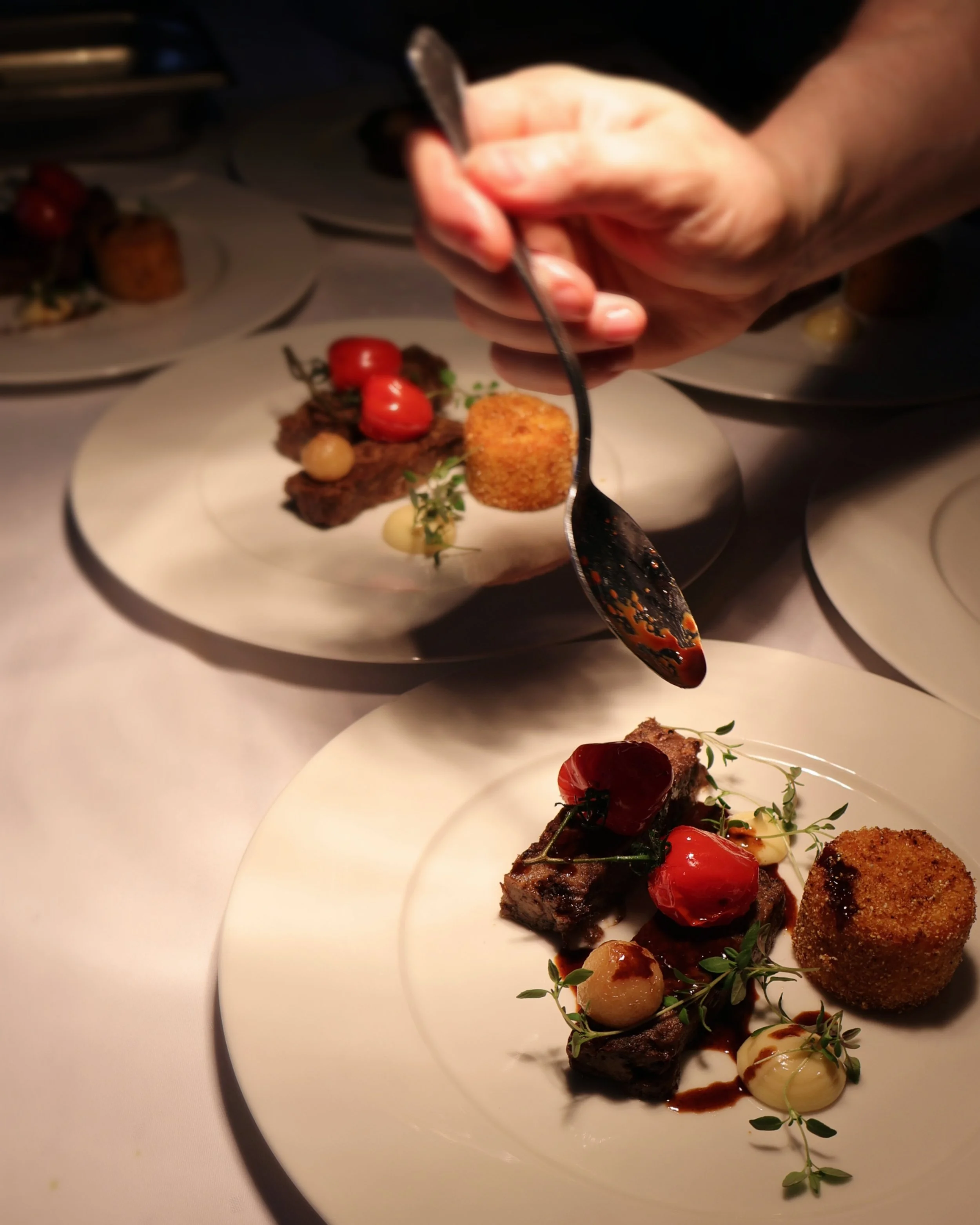 Lähikuva ruoka-annoksen kokoamisesta. Annoksessa riitaa ja maissikakku. Sunilan Kantolan tehtaanjohtajan illallinen.