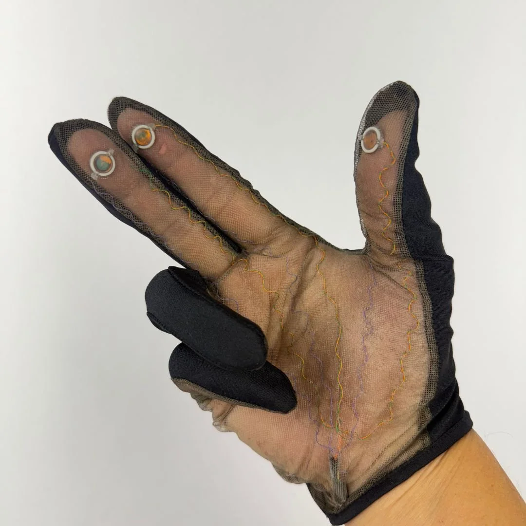 Early PPS DARPA-funded finger tactile sensing glove with capacitive sensors at the fingertips, showing the net fabric construction and visible wiring across the palm.