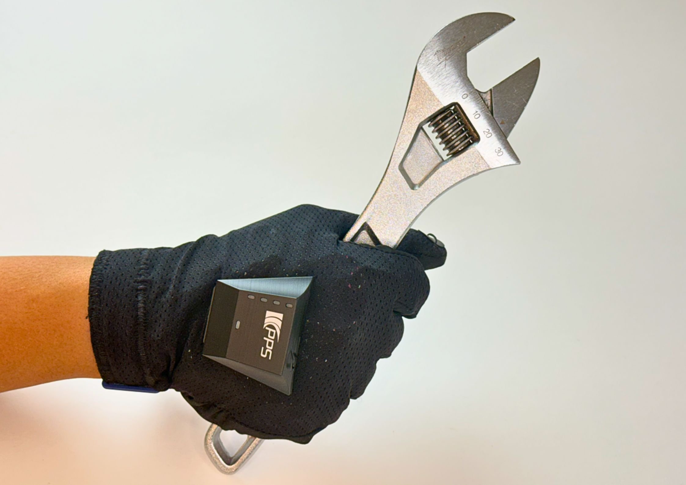 Gloved hand fitted with the PPS TactileGlove system gripping an adjustable wrench.