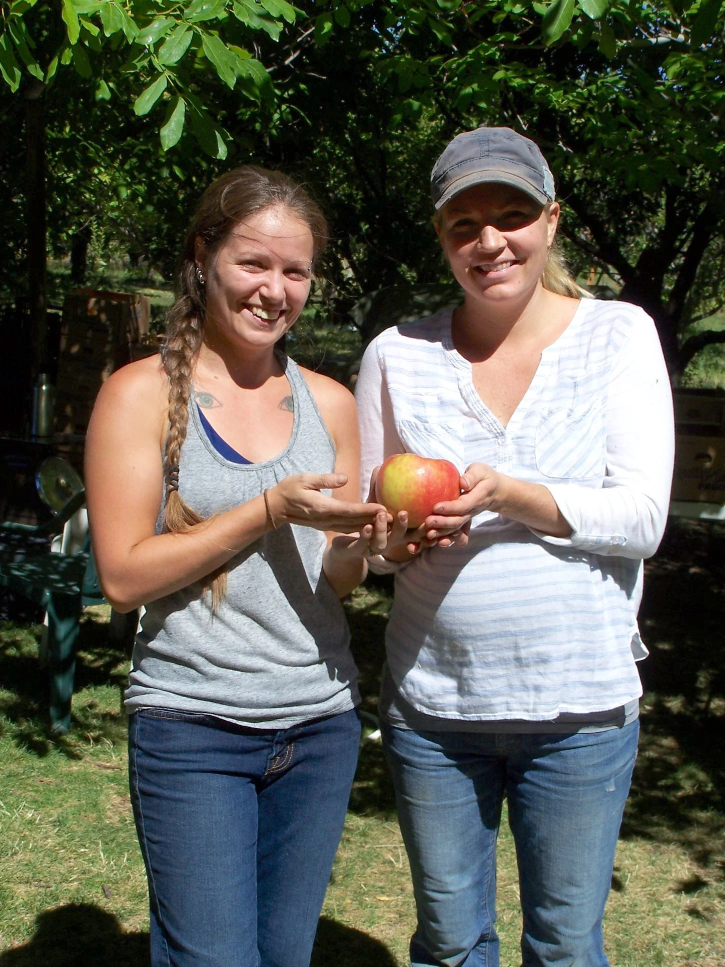 Olivia and Stephonie holding a 1.16 lb Honey Crisp Apple.